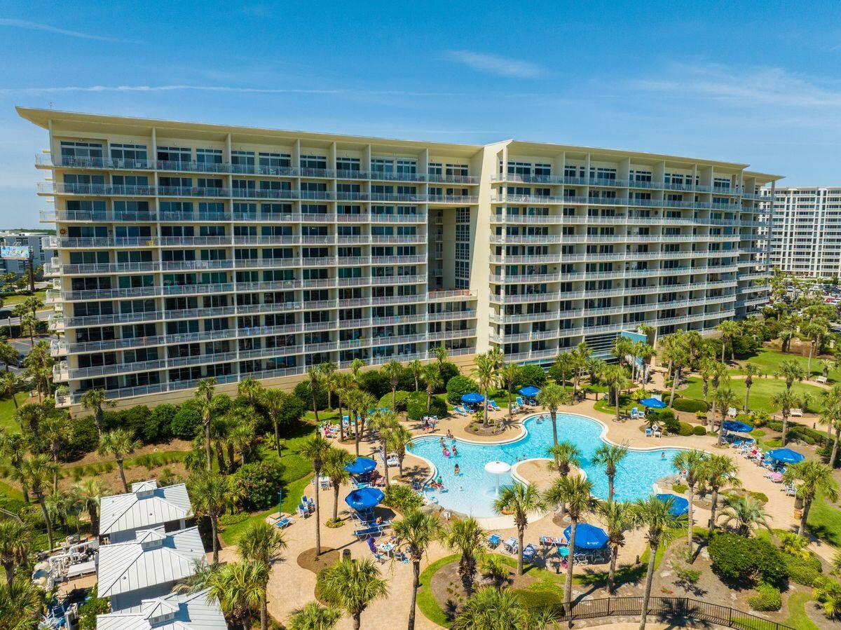 Located within Sterling Shores, this fully remodeled three-bedroom, two-bath condo offers a well-executed layout and immediate access to both the beach and the community's amenities. Positioned on the second floor, the unit allows for quick, convenient entry without reliance on the elevator.

Inside, wood-plank flooring, custom drapery, and a clean, neutral palette carry throughout. The living area is centered around a spacious seating arrangement and opens directly to a private balcony with Gulf glimpses, palm-lined privacy, and sunset exposure. The kitchen is finished with granite countertops, subway tile backsplash, white cabinetry, and stainless appliances, with bar seating and a dining area that comfortably accommodates eight. A separate laundry room adds functional storage rarely found in similar units.

The primary suite offers a king bed, walk-in closet, direct balcony access, and a well-appointed bath with jetted tub and separate shower. Guest accommodations include a queen bedroom and a bunk room with a twin-over-full layout, along with a sleeper sofa to maximize occupancy.

Sterling Shores is a gated, amenity-rich community known for its dual pool offering, including a resort-style pool and a beachfront pool with café service, along with a fitness center, private theater, grilling areas, landscaped grounds, and deeded beach access just a short walk from the residence.
