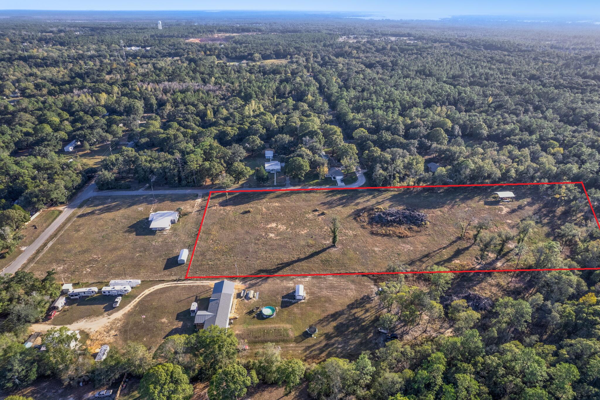 Over 7 acres of cleared, FULLY FENCED land offers an exceptional opportunity for development in a prime location near the intersection of I-10 and Highway 87 in Milton! This property is secured with Industrial-Grade livestock fencing, making it ideal for a variety of agricultural uses or any animals requiring secure enclosure. Zoned for Agriculture, Rural Residential, and Commercial use, this parcel provides flexibility for builders, developers, or investors looking to capitalize on its potential. The land can be subdivided, opening the door to a range of development options -- from private homesteads to commercial ventures. Enjoy the best of both worlds with easy access to major highways and a peaceful, rural setting. City water is available, making this property ready for immediate devel opment. Whether you're planning to build, invest, or expand, this versatile acreage is a rare find with endless possibilities.