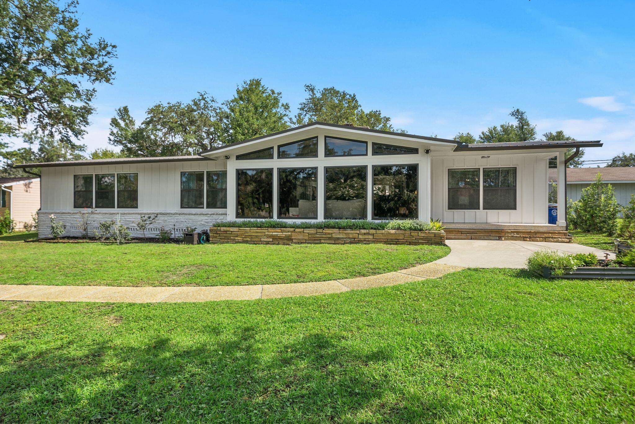 Sitting high on a hill, beneath hundred year old oak trees and on an over 1/3-acre homesite with NO HOA, this 3-bedroom, 2-bath mid-century modern beauty sits directly across from the water in one of Panama City's most historic neighborhoods...The Cove. 

And this isn't a ''close to downtown'' home where you still need to get in the car to go everywhere. This is walk-to, bike-to, golf-cart-to booming Downtown Panama City. Cruise the oak-canopied streets to Trigo San Francisco Style Deli for lunch, grab a coffee (or crepe, or glass of wine!) at The Press, or park the golf cart at History Class for a cold local pour. Waterfront dinner at the St. Andrews Bay Yacht Club? Ten minutes by cart if you're a Member. Downtown's growing lineup of shops, live music, and the regular scheduled community activities like the Saturday Farmer's Market's make living in the Cove even better. 

Step inside, and you're greeted with 2,298 square feet of single-level living with original mid-century modern character. Original terrazzo and heart pine floors run throughout and this is the kind of detail you can't recreate, only preserve. 

The living room is anchored by vaulted, beamed ceilings, gas fireplace, and clerestory impact windows that make you stop in your tracks with the natural light and beauty they bring to this home! The living room flows into the dining room that connects to the kitchen for easy everyday living and easier entertaining. There is a charming light-filled, breakfast room off the kitchen that offers backyard views and the gas fireplace, as well. A large laundry room, home office and storage room are also located off the breakfast room and near the entry to the attached 2-car garage. The 2-car garage is a RARE find in the Cove and with alley access and additional parking, you're going to love the storage and parking for all your friends, family and their golf carts and cars! 

The kitchen was fully reimagined in 2022 with a new, functional layout, gas cooktop, wall oven, microwave, refrigerator, custom cabinetry, electrical, plumbing and marble countertops. The roof was installed in 2020, the exterior was completely renovated in 2024 with hardie board siding and the HVAC system was installed in 2025. 

The primary suite is a true retreat with a large bath, separate shower and toilet area and a large walk-in closet. The other two oversized bedrooms give real breathing room, including larger than typical closets in the Cove. A guest bath is easily accessible from the hallway for both guests and two guest bedrooms and is a fun nod to the mid-century modern design! 

This home offers NO HOA and is just a rare mid-century gem, perched up high on a hill, in a charming neighborhood where the water's across the street and downtown's a golf cart ride away. 

If you're ready to start really living in the Cove, this mid century modern beauty is move-in ready for you to call home!