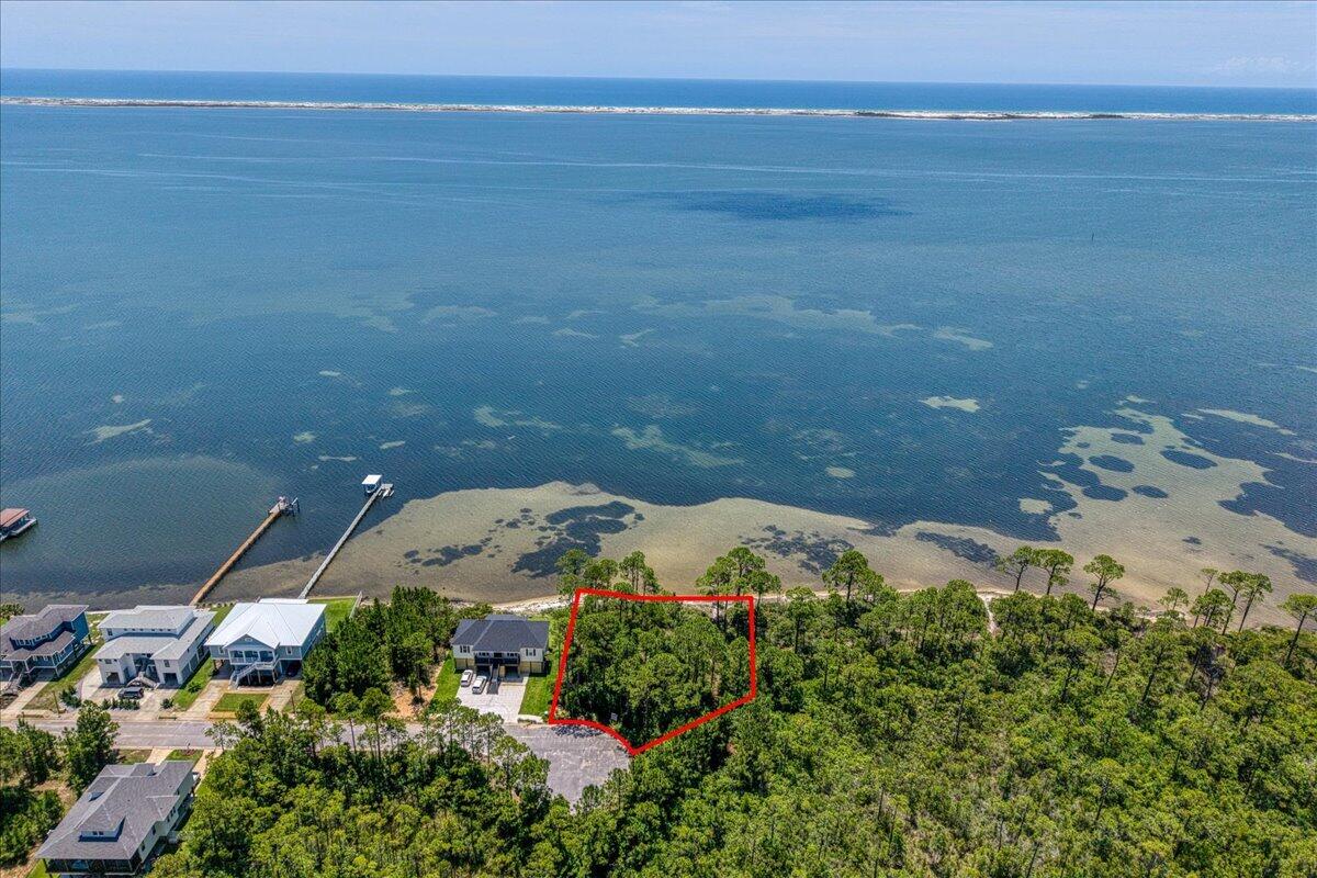 Build your dream waterfront retreat on this beautiful homesite, offering approximately 150 feet of frontage on the Santa Rosa Sound! Tucked away at the end of a quiet cul-de-sac, this exceptional lot provides privacy, tranquility, and breathtaking water views. The generous lot offers ample room for a custom residence, a dock and private pool, allowing you to design the ultimate coastal oasis. Enjoy your own private stretch of beach, creating the perfect setting for relaxing, fishing, paddleboarding, or simply taking in the stunning sunsets. Water and sewer are available, and a survey along with a 2018 Wetlands Assessment Report are available for review. Set in a quiet neighborhood setting with no active HOA, you'll enjoy added flexibility as you bring your vision to life. Added bonus: you're only 10 minutes away from Woodlawn Beach Boat Ramp! Come experience the beauty of Santa Rosa Sound and create the waterfront lifestyle you've always imagined!