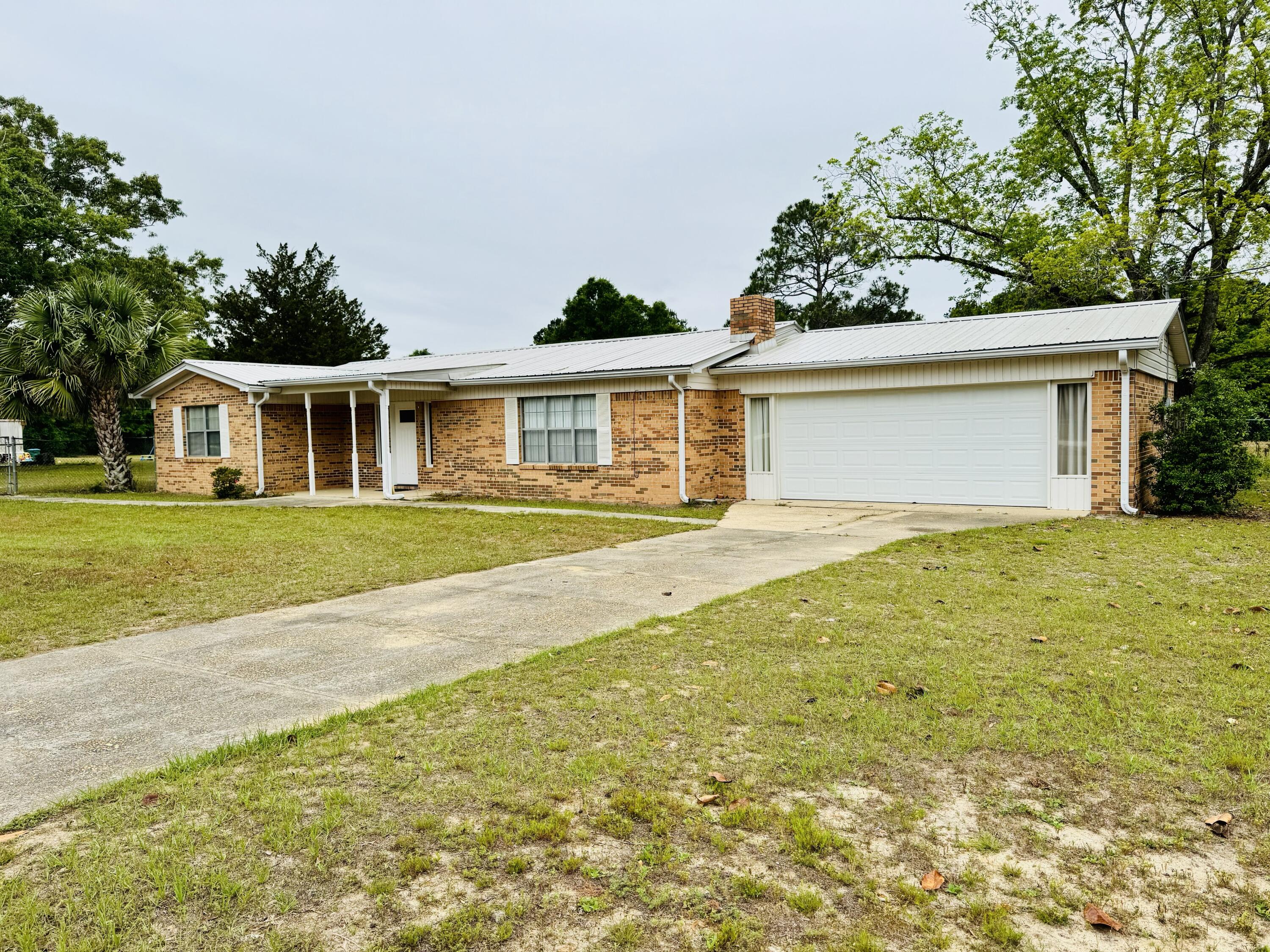 Charming brick home just minutes from stunning Lake Jackson in Florala! This 3-bedroom, 2-bath brick home sits on a spacious one-acre lot with a fenced front yard, offering both privacy and room to grow. The freshly remodeled kitchen shines with new appliances, modern cabinetry, and ample counter space. Recent updates include a new water heater, garage door, carpet and tile flooring, and a sliding glass door that opens to the peaceful backyard. A metal roof (installed 4-5 years ago) ensures years of low-maintenance living. Enjoy quiet mornings on your porch or easy access to Lake Jackson for boating, walking, and enjoying the best of small-town Alabama charm.