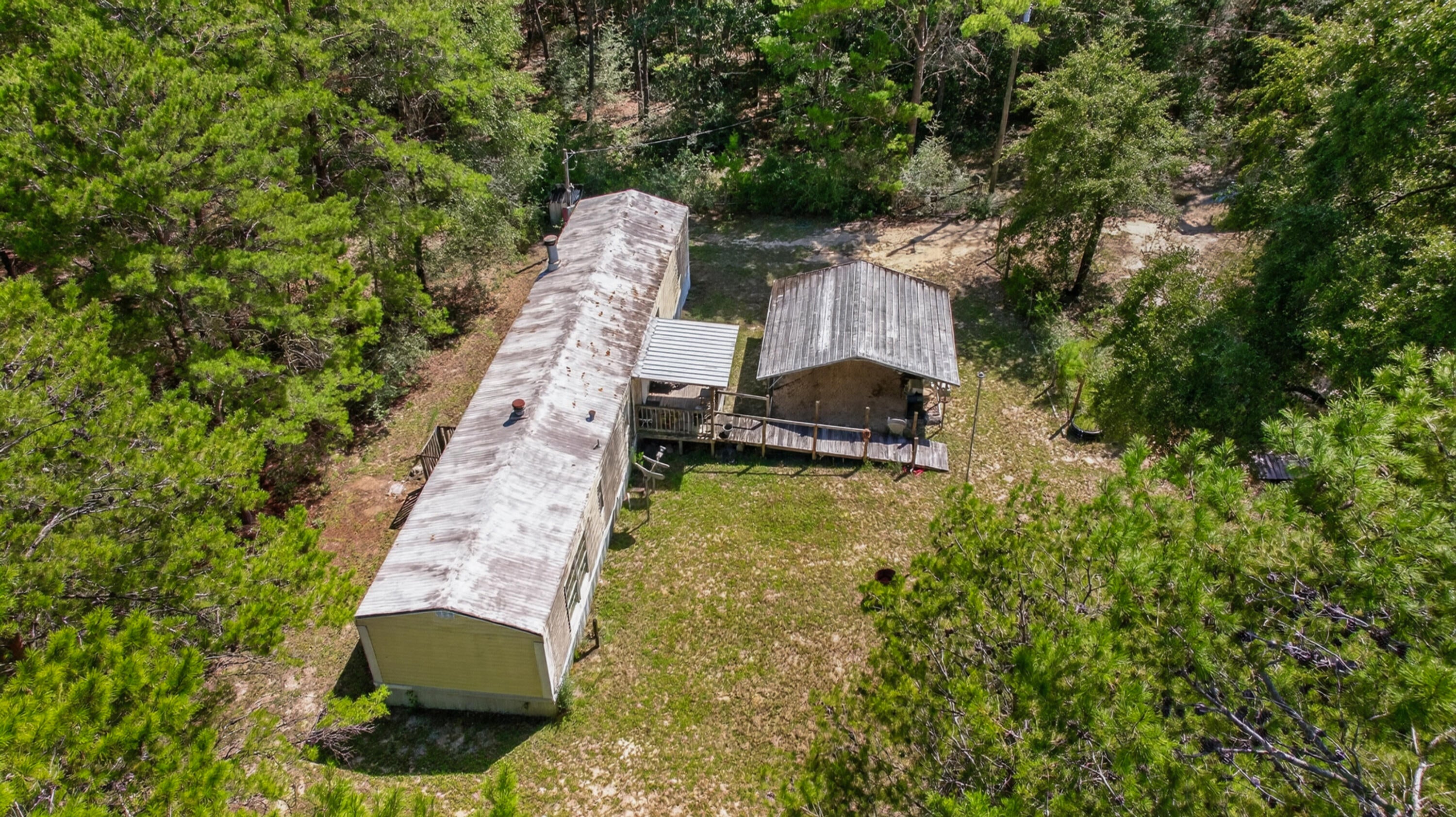 Escape to your own private 10-acre retreat with endless possibilities! Tucked away down a winding, tree-lined driveway, this secluded property offers the space, privacy, and peaceful country setting that can be hard to find - all while keeping you conveniently close to town, I-10, and the Blackstone Golf Course.

The property is currently improved with a mobile home that is being sold AS-IS and is ready for someone with a little vision. Bring it back to life with some TLC, use it as an investment property, or remove it and take advantage of the acreage to build your dream home from the ground up. The property grossed over $13,000 in rental income in 2017, offering additional potential for an investor or buyer looking for a property with income-producing possibilities.

Surrounded by spacious 10-acre parcels, you'll have plenty of room to spread out and enjoy the outdoors without giving up convenient access to everyday amenities. The wraparound driveway provides easy access and plenty of room for vehicles, trailers, boats, or recreational toys. The existing home features a covered front deck perfect for enjoying quiet mornings and country breezes, along with a cozy fireplace inside. Recent improvements include an updated well, dishwasher, and stove. Additional features include vinyl siding and tile flooring throughout several areas of the home.

Whether you're searching for acreage, an investment opportunity, a weekend getaway, or the perfect piece of land for your future dream home, this 10-acre property offers the freedom and flexibility to make it your own. Come for the land, stay for the privacy, and imagine the possibilities!