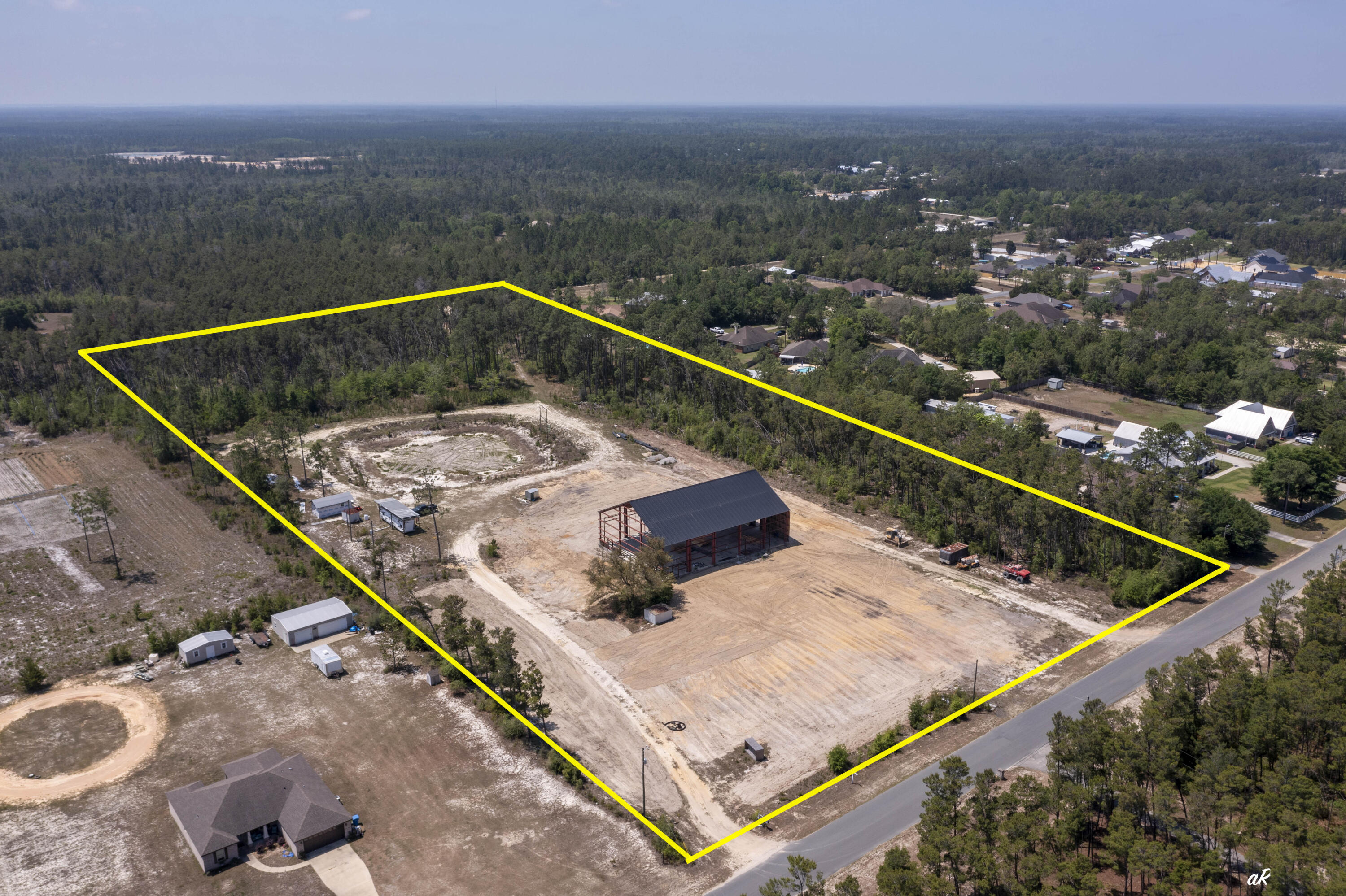 Highly Motivated Seller! 11 ACRES! Bonus!  Seller will remove the existing red iron building and offer a $25,000 price reduction, creating added flexibility and opportunity for future use of the property. Rare opportunity in booming Southport! This 11-acre property offers the space, privacy, and flexibility that is almost impossible to find today. Located on a paved road with no HOA, this property gives you the quiet lifestyle people want while still being close to everything--about 10 minutes to Lynn Haven, 20 minutes to the airport, and 30 minutes to the beaches and Pier Park. With new construction and growth expanding north, this is a prime opportunity for a private estate, family compound, or potential subdivision for multiple homes or spec builds. The property already has septic, well, power, and full camper hookups on site. There is plenty of room for your RV, boat, heavy equipment, and all the toys, plus space to create your own micro-farm with chickens, horses, goats, and more. A massive red iron building has also been started, offering approximately 14,000 square feet of heated and cooled space when completed. Permits are pulled, and a floor plan is available. Whether you are looking for land, privacy, investment potential, or room to build something big, this Southport property is an opportunity worth paying attention to, come tour today!