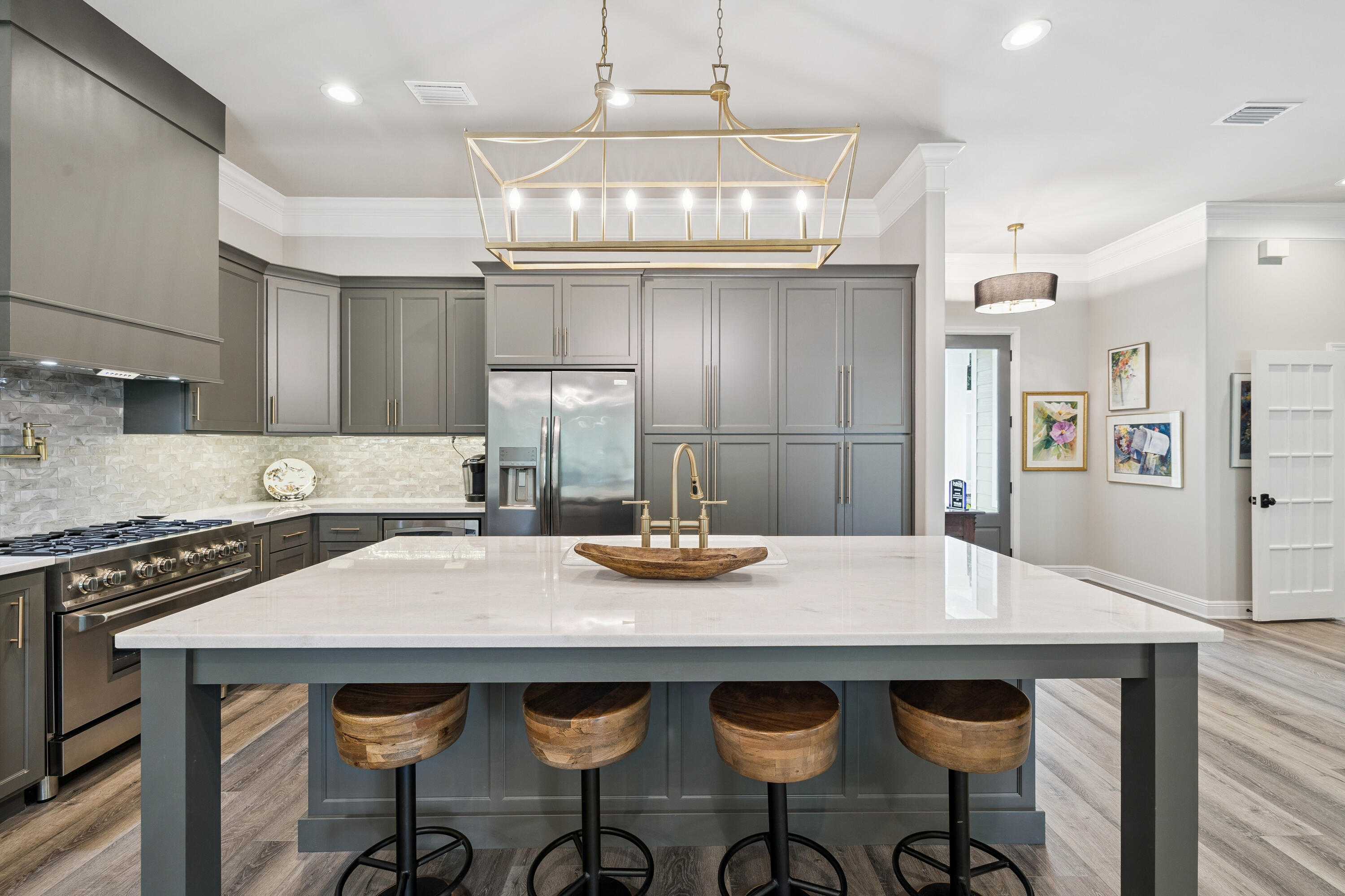 Welcome to this spectacular, move-in-ready coastal retreat, beautifully transformed by a top-to-bottom remodel in 2022. Offering a refreshing escape from Destin's typical high-density, zero-lot-line neighborhoods, this home is nestled on an expansive, private lot shaded by majestic mature oak trees. A sweeping circular driveway provides exceptional curb appeal and ample parking, leading to a finished, oversized garage with a showroom-quality premium floor coating. Inside, complete peace of mind comes standard with a new roof, new windows, and luxury new flooring throughout.Designed with an ideal split floor plan for maximum privacy, the heart of the home centers around a breathtaking chef's kitchen and an inviting living room anchored by a cozy fireplace. The kitchen is an entertainer's dream, featuring a massive quartz island with bar seating, custom gray cabinetry reaching to the ceiling, a contemporary tile backsplash, and a premium gas range. Spanning nearly the entire length of the back of the house is the show-stopping Florida sunroom. Flooded with natural light, this massive bonus space acts as an airy secondary living room, effortlessly drawing the tranquil, treed outdoor setting indoors.Retreat to the luxurious primary suite, a private sanctuary boasting its own romantic fireplace and two spacious walk-in closets. The master bath is fully updated, offering a separate soaking tub and walk-in shower alongside a double vanity layout for ultimate convenience.  The secondary bathroom is equally updated with modern, high-end finishes. In addition to the three dedicated bedrooms, a flexible private home office easily serves as a fourth bedroom, custom home gym, or playroom. The home also features a large, independent laundry room complete with a utility sink.