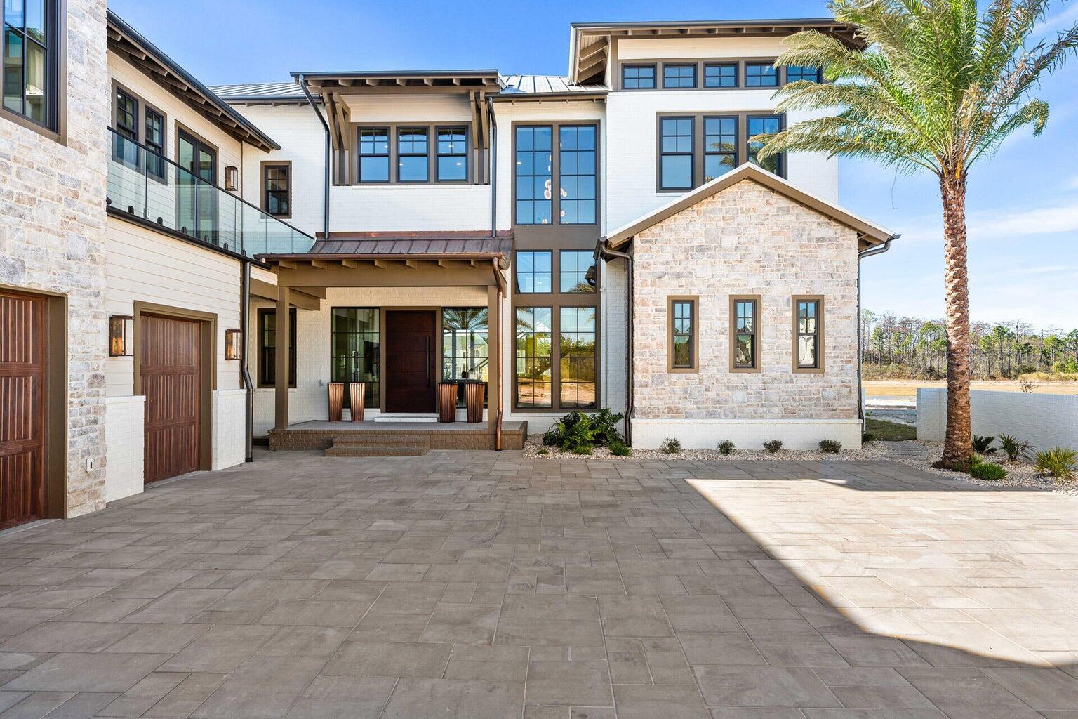 A masterful expression of modern coastal luxury, 75 N Southern Cross Lane offers an extraordinary residential experience within the private, gated enclave of WaterSound Camp Creek. Spanning nearly 7,000 square feet, this 2025 Parade of Homes award-winning residence has been thoughtfully conceived to balance architectural distinction, sophisticated entertaining, and effortless everyday living. From the moment you enter, soaring beamed ceilings, expansive proportions, and beautifully curated finishes establish a sense of understated elegance. The heart of the residence is a spectacular chef's kitchen designed for both intimate gatherings and grand-scale entertaining, complemented by a discreet service kitchen that allows the main living spaces to remain polished and composed. Five beautifully appointed bedrooms include dual primary suites, providing exceptional privacy and flexibility for owners and guests. Beyond the principal living spaces, the home unfolds into a remarkable collection of amenities: a private theater, executive office, fitness room, expansive game and entertaining room with wet bar, elevator, two laundry rooms, and an oversized garage. A dedicated private wellness suite transforms the home into a personal retreat, complete with a steam room, dry sauna, cold plunge, and private shower--an uncommon luxury designed around restoration and well-being. Outdoors, the residence embraces the relaxed sophistication of the 30A lifestyle. A heated pool and spa overlook  tranquil pond views, creating a serene backdrop for afternoons in the sun and evenings under the stars. An outdoor kitchen extends the entertaining experience beyond the interiors, while a detached carriage house with its own entrance and full kitchen provides an elegant, private retreat for extended family or guests. Set within WaterSound Camp Creek, one of Northwest Florida's most coveted communities, the residence offers exceptional proximity to the sugar-white sands of the Gulf of Mexico and the celebrated dining, shopping, and coastal communities of Scenic Highway 30A. Eligible owners may also pursue membership opportunities with WaterSound Club, further enhancing the lifestyle with access to an exceptional collection of golf, beach, dining, fitness, tennis, pickleball, pool, and resort amenities. 75 N Southern Cross Lane is more than a residence--it is a private coastal retreat where elevated design, resort-caliber amenities, and the coveted WaterSound lifestyle come together in exceptional fashion.