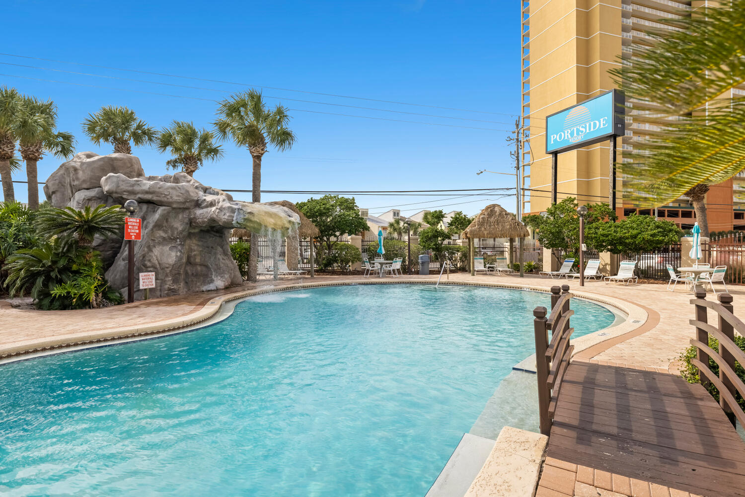 Tucked away in the highly sought after West End of PCB, this charming 2 bedroom, 2.5 bath condo in Portside Resort offers the perfect blend of beachside relaxation, convenience, and investment potential. This rare floor plan stands out with two full bathrooms plus a half bath, a hard to find feature in the community. The spacious primary suite offers its own private bath and balcony, creating the perfect spot to start your day with coffee and coastal breezes. Ideally located within the resort, Unit N5 is near by one of three community pools, including a beautiful waterfall pool and a seasonally heated pool, with plenty of space to kick back and unwind. Portside offers so many amenities designed for both owners and guests, including a hot tub, tennis and pickleball courts, shuffleboard, horseshoes, a fitness room, and beautifully landscaped grounds. The large clubhouse offers a fun gathering space complete with a pool table, darts, card tables, and a full kitchen, perfect for hosting everything from casual dinners to game nights. Even better, you are directly across from Beach Access 70 and right next door to local favorite Carousel Supermarket, making beach days and quick grocery runs effortless. You are also just minutes from Pier Park, Pirates Voyage Dinner & Show, Topgolf, McGuire's Irish Pub, and the scenic charm of 30A. With similar units producing over $25,000-40000 annually in gross rental income, low HOA fees, and no milestone inspections, this is an incredible