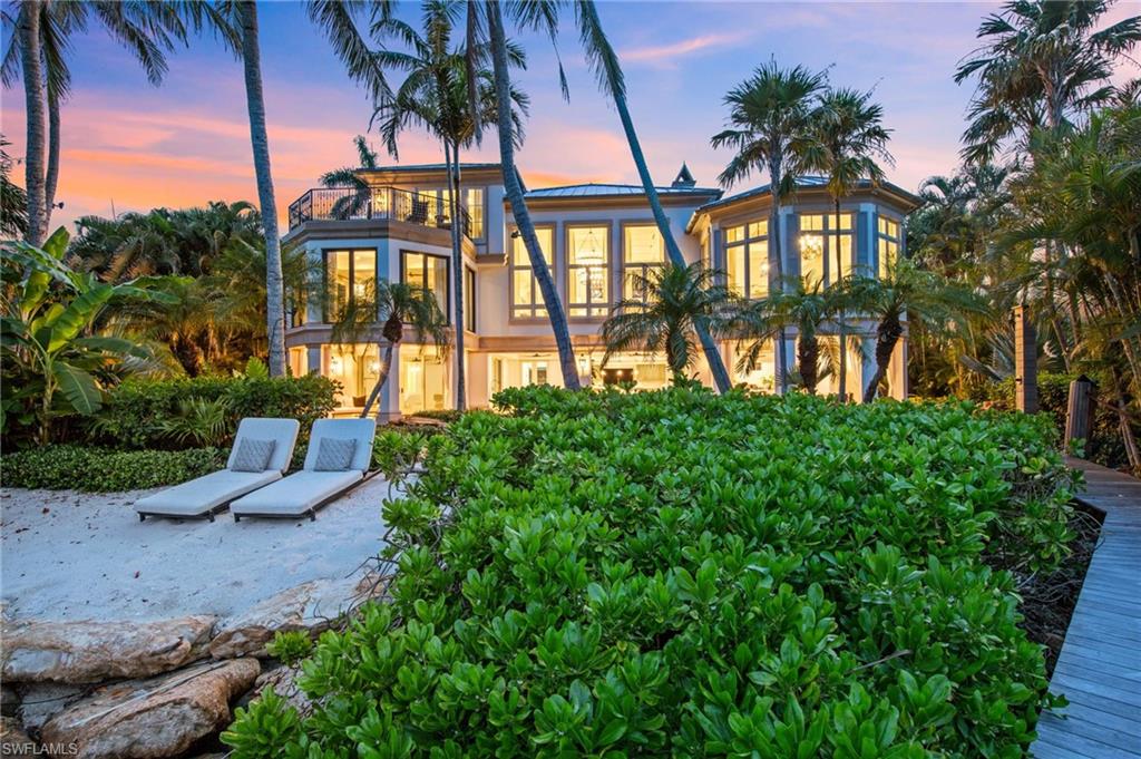 IMMEDIATE RESIDENT FULL PORT ROYAL MEMBERSHIP! Perched against the stunning backdrop of Champney Bay, this exquisite property, inspired by the aesthetics of the French West Indies, has been thoughtfully designed by the acclaimed architect Jeff Harrell. After an extensive two-year whole home renovation completed in 2022, the estate underwent a comprehensive outdoor and lower-level renovation in 2024, executed by the esteemed Knauf-Koenig Group. This remarkable multi-structure Port Royal residence boasts five bedrooms, a den, and 6.5 bathrooms, masterfully fusing timeless elegance with modern luxuries. Upon entering this captivating home, you are immediately surrounded by an array of ultra high-end finishes and contemporary details, creating an ambiance of refined sophistication throughout. The gourmet kitchen is a culinary dream, featuring premium Officine Gullo and Gaggenau appliances. The stunning primary suite, which occupies an entire level, serves as a personal retreat. It offers a private waterfront balcony, expansive mahogany walk-in closets, a convenient morning kitchen, and a lavish bathroom adorned with an exquisite mother-of-pearl domed ceiling, cultivating a serene yet luxurious atmosphere. The outdoor areas are reminiscent of a high-end resort, showcasing a magnificent pool, a peaceful koi pond, and a remarkable double-sided marble fireplace that enhances the natural beauty of the surroundings. The thoughtfully designed outdoor kitchen, private sandy beach cove in addition to private beach access off Gordon Dr, and various terraces provide an ideal setting for seamless entertaining amid lush tropical landscaping. Additionally, this home features private beach access and a dock located just a short distance from Gordon Pass allowing for direct access to the gulf, making it perfect for boating enthusiasts. For car aficionados, the estate features three garages with the capacity to accommodate up to nine vehicles or 13 vehicles with lifts. Residents enjoy exclusive membership eligibility to the prestigious Port Royal Club, adding yet another enticing aspect to this extraordinary property.