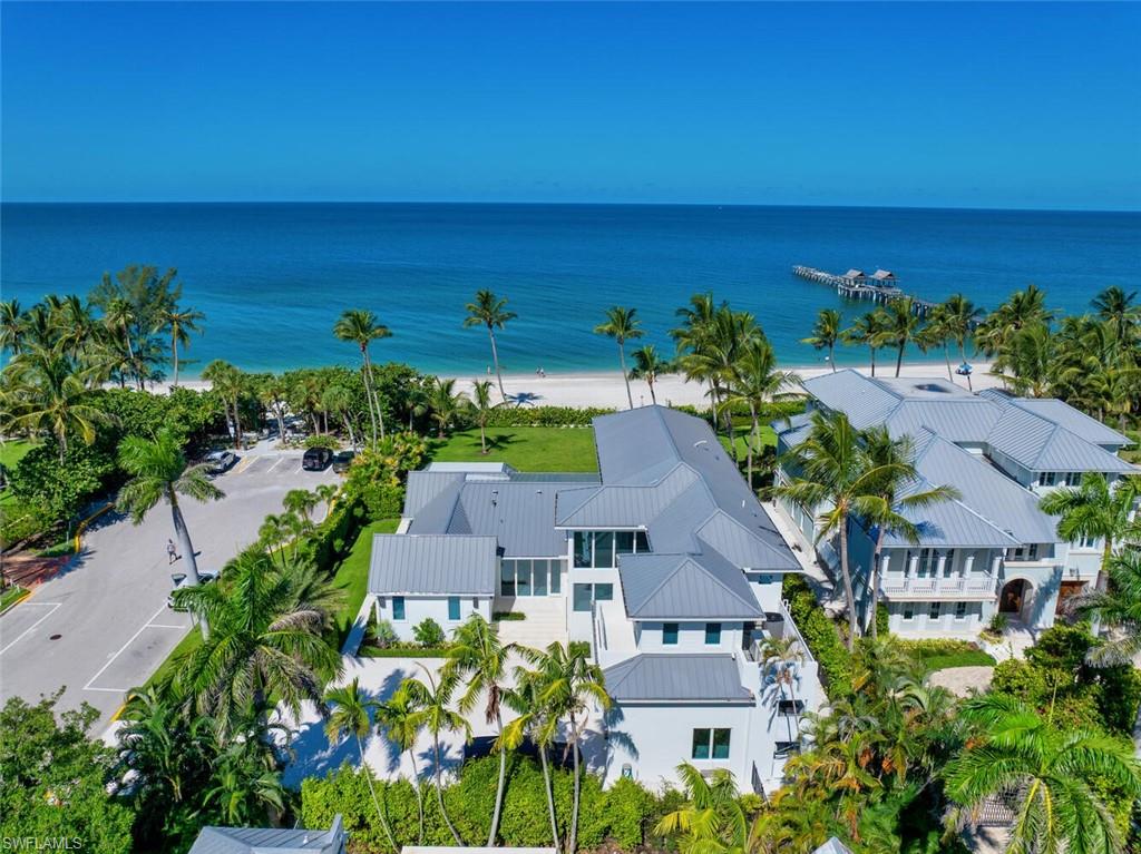 This Gulf-front masterpiece offers an unparalleled blend of location, luxury, Gulf views, and resort-style living. Completely rebuilt in 2024 by Kukk Architecture and The Lykos Group with the exception of one exterior wall to utilized the grandfathered setbacks and maximize an oversized building envelope. The home has experienced no water intrusion in living areas during recent weather events. The residence combines historic charm with sophisticated elegance. Originally built in 1886, the home underwent an extensive three-year renovation and reconstruction. Now practically new, the residence preserves its heritage, grandfathered footprint, and distinctive character while offering modern luxury throughout. The 6,100-square-foot, fully air-conditioned living space maximizes its premier beachfront setting. The well-designed layout offers five spacious bedrooms, five full and two half baths, a private study, and a flexible sixth bedroom. Sweeping Gulf views provide a stunning backdrop. The gourmet kitchen boasts dual Cristallo quartzite islands, top-tier appliances, custom cabinetry, and a service kitchen. Additional features include a private gated entry, two fireplaces, elevator, whole-house generator, automated screens/shutters, water filtration, and ultra-efficient air conditioning. Perfectly positioned on the Gulf, just moments from the dining and boutique shopping of Third Street South and Fifth Avenue South. A rare opportunity in the heart of Old Naples.