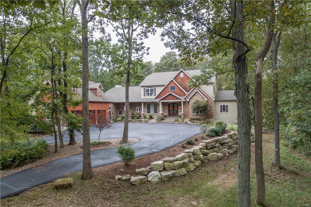 Cust. 1.5 story home on 5.8+/- ac lot. Access to over 800+ac of Babler park via a private trail, miles of hiking, biking & riding trails. The outdoor oasis boasts natural stone landscaping feat. 2 tranquil water features flanking stone steps to a hand cut stone patio & firepit. An outdoor ktchn, hot tub & tree house lend to a relaxing resort feel. Home has perfect flr plan for entertaining. Great RM w/gas FP offers view of landscaped & wooded backyard. Gourmet kitchen has kemper cabinets, granite counters, Hans Grohe fixtures & SS Thermador appliances, open to the hearth RM w/woodburning FP. Master has 2 walkin closets, updated bath w/jacuzzi tub, walkin shower w/river rock flr rainfall shower head & body sprays. Also feat. 4 add. bdrms w/walkin closets, finished walkout LL w/bdrm, rec rm, media rm, exercise rm(could be 6th bdrm), wet bar, full bath & huge storage area. 3 Car oversized garage w/builtin loft, storage shed, & add. acreage may be available. No Subdivison, no HOA fees. Additional Rooms: Mud Room
