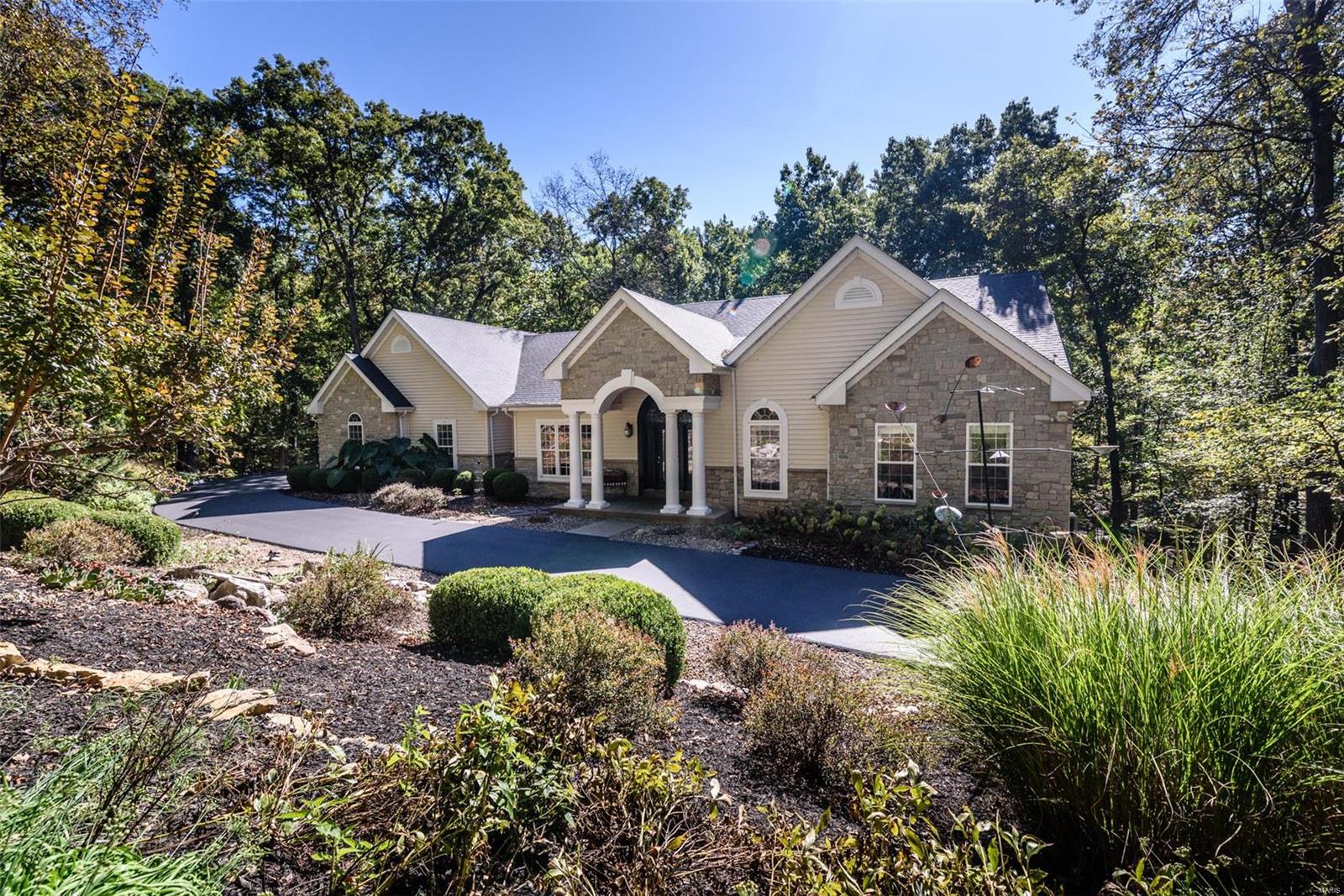 This stunning custom-built atrium ranch has over 4,100 S.F. of total living area and is nestled on 3.3 beautiful, wooded acres. Located in a highly sought-after, peaceful, private setting, it’s just 10 minutes from Highway 40-64 and Chesterfield Valley. This meticulously maintained, one-owner home features numerous upgrades, including elevated vanities and fixtures, two custom fireplaces, a sauna, central vacuum system, and a spacious walk-in pantry. The open floor plan is versatile and inviting, with vaulted ceilings, premium hardwood flooring, and beautiful slate flooring. This spacious home boasts five walk-in closets for ample storage, an oversized finished three-car garage, and recent updates including a new driveway, roof, HVAC system, and GE Profile refrigerator and dishwasher. With a natural gas furnace and cooktop, this home is equipped for comfort. Outdoor living is a delight with a deck, screened-in porch, and a unique stone patio, all surrounded by professional landscaping.