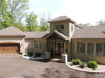 This is a stunning, one of a kind, custom home on Alpine Lake at Innsbrook. Designed for entertaining it features 4 large bedrooms each with a private bathroom. Perfect to host multiple families without feeling cramped. Marvel at the amount of natural light the Florida-esque style allows. You'll notice water views, trees, and light as you enter the 2-story foyer. The 100-yr-old clearstory stained glass windows were salvaged from a rural church built around the turn of the century. The custom kitchen includes stainless appliances, 2 dishwashers, marble countertops, and a large center island. The kitchen opens to the vaulted great room and dining area. A massive floor to ceiling fireplace adorns one wall. Enjoy morning coffee in the birds nest loft. The 2nd story views of the lake and woods are phenomenal. The lower level has a large living space with two bedrooms plus a wet bar. There are two private decks, a patio, and docking area on the lake. Alpine Lake is Innsbrook's largest lake!