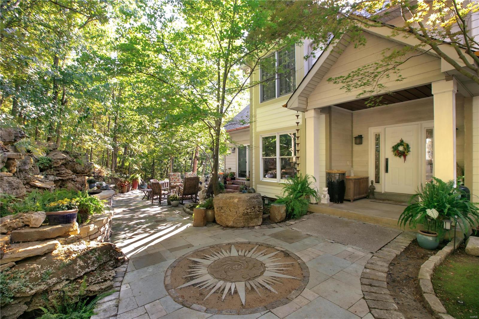 A Nature Lovers Dream. Inspired by the Missouri Botanical Gardens, this property has been transformed into the perfect retreat with sweeping views all the way to Hidden Valley Ski Resort, abundance of flowers and fauna, custom waterfalls, multi tiered decks and patios with multiple outdoor gas fireplaces, all encompassed by a private nature path on a 3 acre lot. The home features 5 Bedrooms, 5 bathrooms, and over 5,000 SF of living space. Nearly every room has oversized windows to take in the unbelievable panoramic views, every season. Main level Primary Suite has sliding doors to patio with enormous waterfall that integrates naturally into the hillside. Great Room features a wall of windows, see-through gas fireplace, and wet bar. Eat-in chefs kitchen includes every amenity and is surrounded by decks and a 4-Season glass enclosed porch for year round entertaining. Lower level finished and above grade makes perfect rec area. Heated driveway. Main level laundry. Truly one-of-a-kind.
