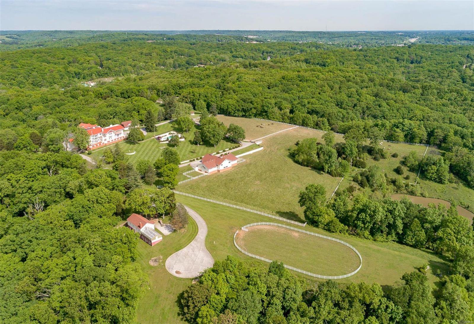 Breathtaking estate on 120 sprawling acres!  Home is perched at the peak of the property overlooking the stunning views of the Mississippi River. The property has a fine equestrian facility housing 12 horses and a riding ring adjacent, lovely pool/spa, as well as a carriage house, greenhouse, and caretakers home.This is an incredible opportunity to keep the property as a private estate or develop part of the acreage. A great room, living room, dining room are all on a grand scale with an amazing staircase reflecting the stature the home deserves. Both levels have complete primary suites with 6 beds/7baths, maids quarters and so much more.  The terrace wraps around the home offering the perfect vantage point for viewing the spectacular grounds, pool, and water. Additional Rooms: Sun Room
