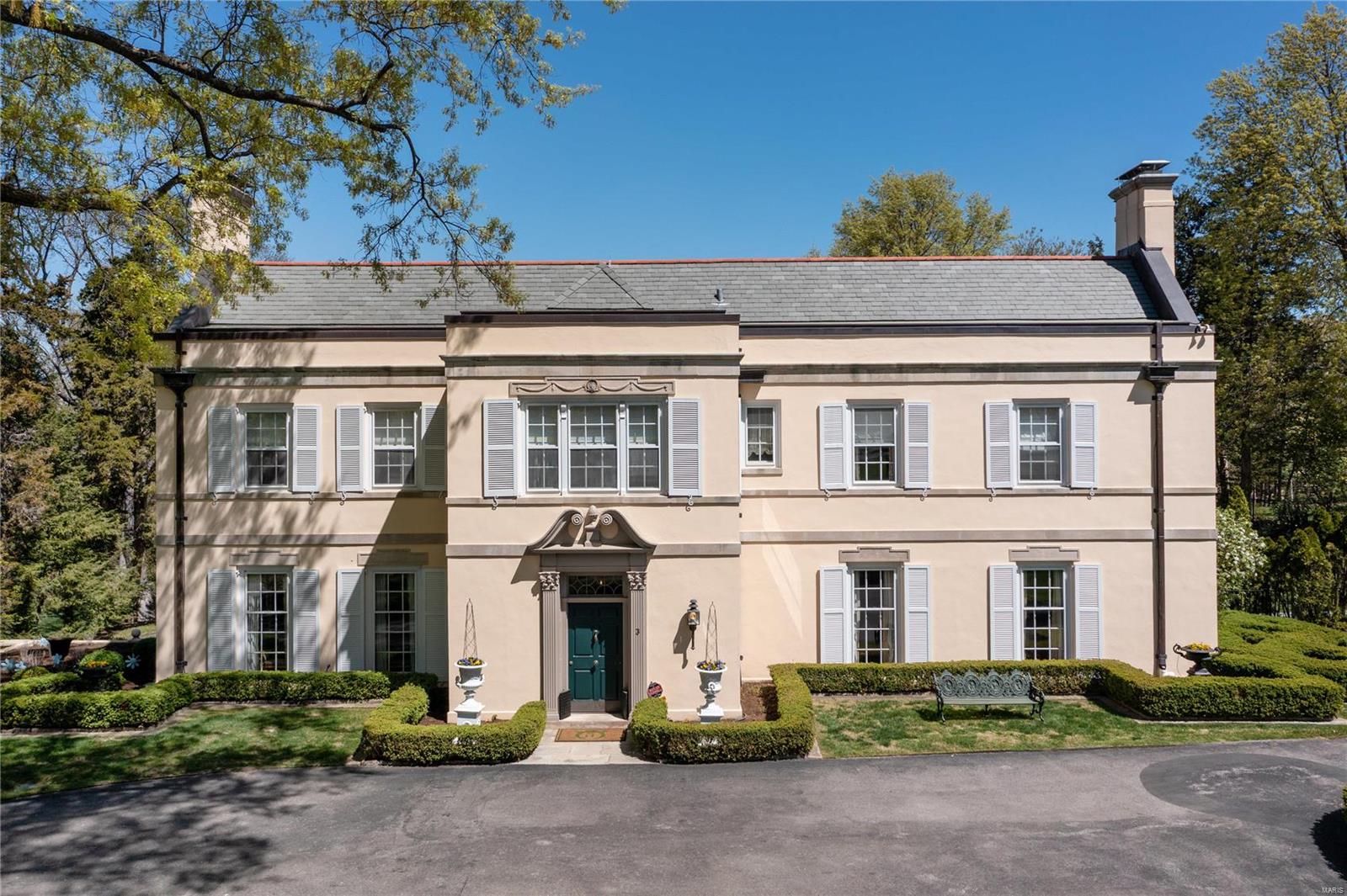 Located in one of Saint Louis' prestigious neighborhoods, this 2.04-acre estate is a classic 6-bedroom, 6.5-bath home designed by Study and Farrar. Antique wood envelopes the formal living room and dining room, accompanied by extensive millwork and period hardware, creating a timeless elegance. The kitchen is a chef's dream, with a generous center island, custom cabinetry, and Subzero and Wolf appliances. The main-floor Primary suite offers views of the pool, and an en-suite bath, soaking tub, and separate shower. Rounding out the first floor, a cozy den with French doors leads to the stunning bluestone terraces, pebble tec pool, and large, private backyard. The other three bedroom suites have walk-in closets and en-suite baths. Two additional bedrooms share a dual-access full bathroom. Established landscaping, circle drive, generator, and newer high-efficiency HVAC.