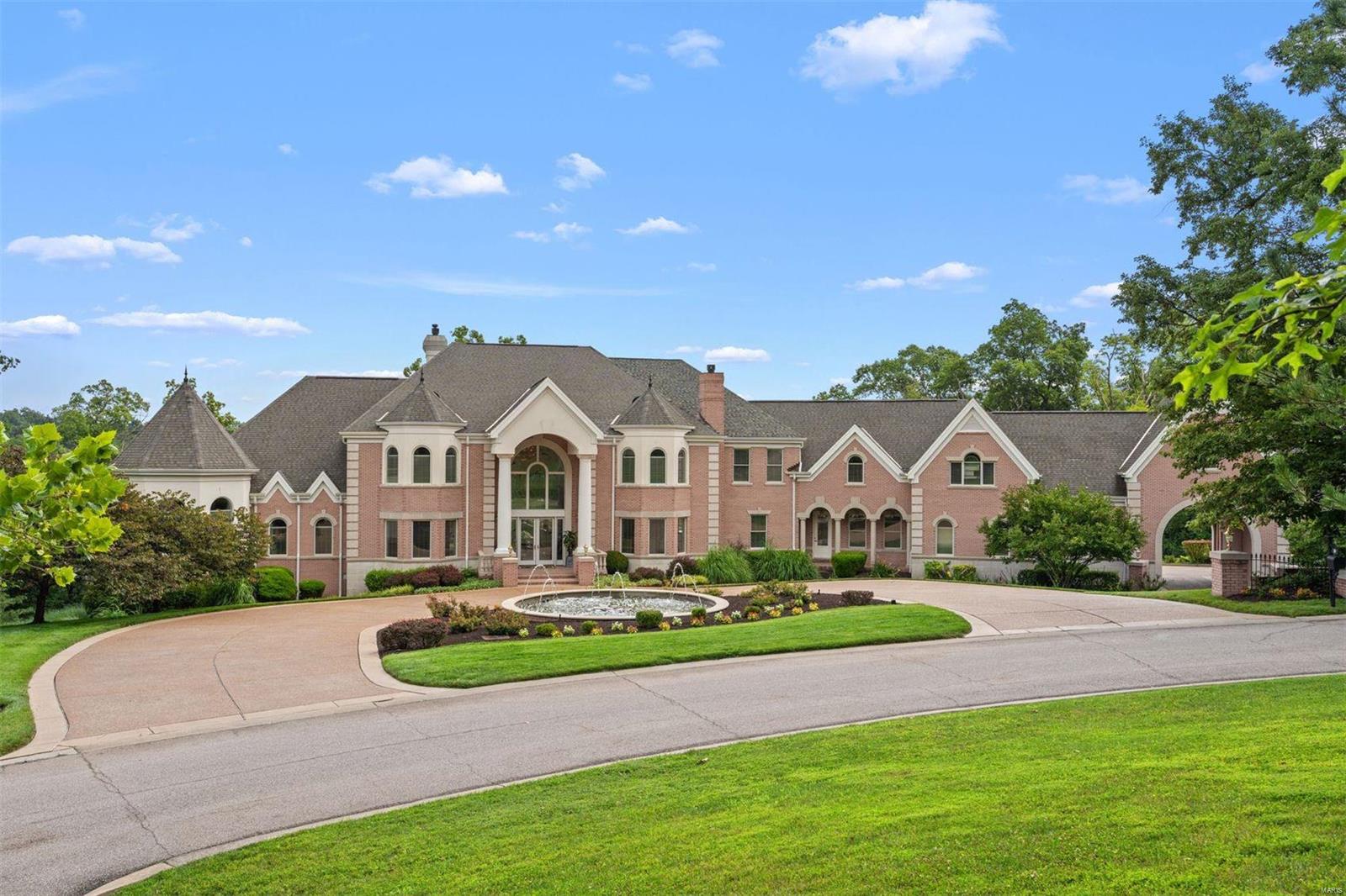 Secluded on 3.15 acres, this exquisite property offers resort amenities, breathtaking views, and a park-like ambience. A grand reception hall and sweeping stair rotunda unite inspiring gathering spaces with soaring ceilings and windowed walls. The main floor hosts a vaulted primary suite with a spa bath, two walk-in closets, and a private terrace. Additionally, there is a second en-suite bedroom on the first floor, allowing for a variety of needs. Upstairs are 5 en-suite bedrooms, a gas fireplace, hall bath, recreation, and laundry rooms. A playful lower level entertainment complex features a full kitchen and separate bar, a screening room, a performance stage and dance floor, and a wellness center with steam, sauna, and fitness rooms...all opening to tiered patios, an infinity edge pool, fountains, a tennis court, and a 6-car garage with Porte Cochere. Additional features are an elevator, 7 fireplaces, whole house smart sound, surveillance, and lighting.  An exceptional opportunity!