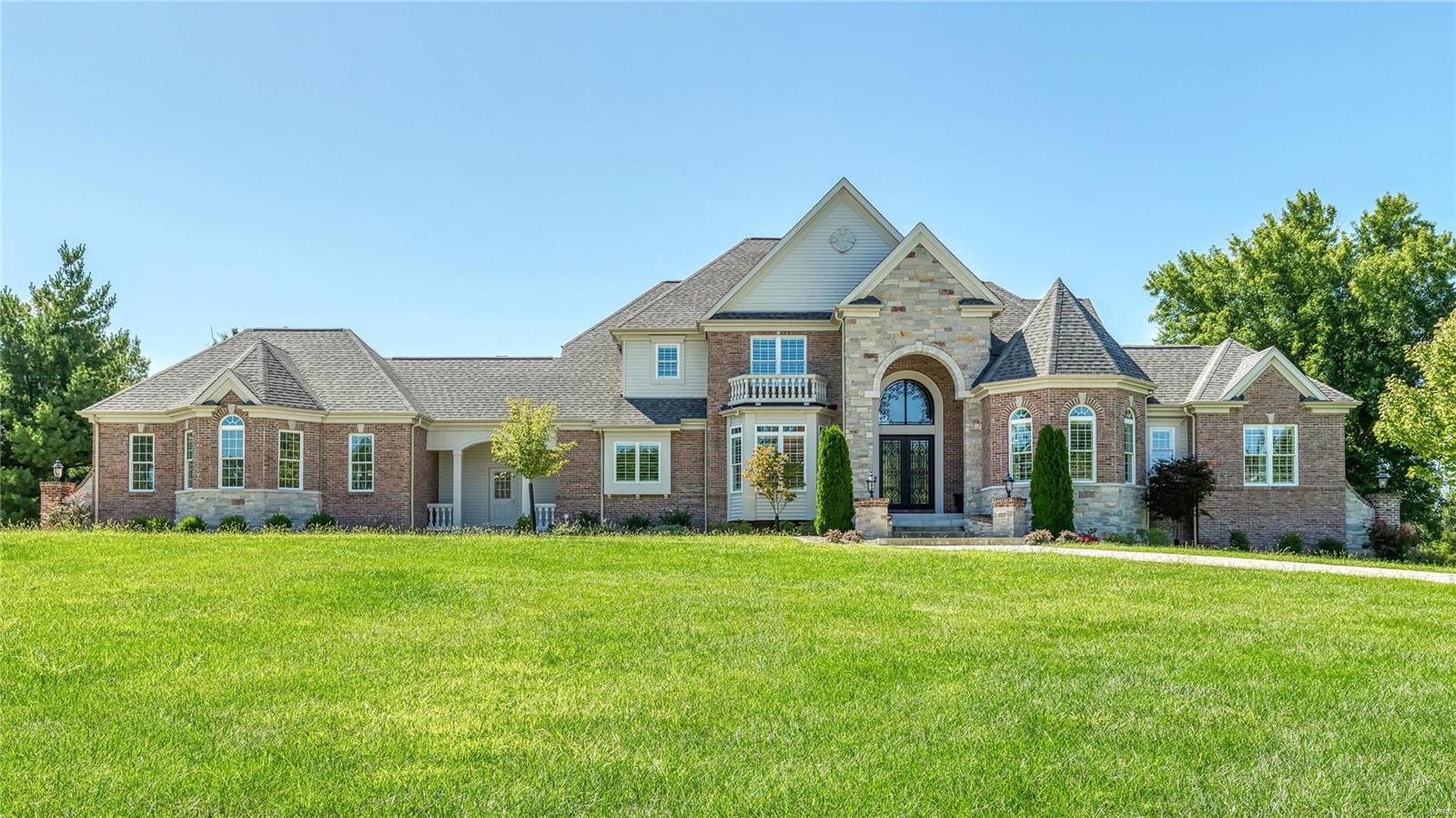 Exquisite 1.5-sty Estate home from Bruning Homes! Over 7500 sf of living space enhanced by soaring ceilings, elaborate millwork, palladian windows & wide plank oak flooring. 2-Sty marble foyer highlighted by dramatic curved staircase leads to private study, elegant dining room & great room with marble fireplace & 2-sty wall of windows. State-of-the-art kitchen with 42” white cabinetry, granite countertops, commercial grade appliances & butler’s pantry adjoins breakfast room with beamed cathedral ceiling, hearth room with stone fireplace & built-in bookcase & vaulted gathering bar.  Coffered master bed suite with marble bath with jetted tub & shower spa plus a 2nd bedroom suite complete the main floor living quarters. The 2nd floor has 3 additional bedrooms with ensuite baths. Lower Lev entertainment space features rec. room with 3rd fireplace, 2nd kitchen, workout room & guest suite, plus an elevator that services all 3 floors. Situated on 1.2-acre grounds with patio & 3-car garage. Additional Rooms: Mud Room
