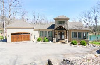 This stunning home with over 4,100 sq. feet of living space is located on Innsbrook Resort's premier Alpine Lake. Enjoy lakeside living at its finest with four separate master suites and towering ceilings. You'll notice substantial windows in every room of the home, allowing views of the surrounding woods and lake. Plus, the soaring entry hallway with antique stained glass church windows adds a charming touch. The upper loft offers premium bird's eye views - perfect for stargazing or reading. Entertaining is a breeze in the magnificent kitchen, two covered decks or patio. The finished lower level has tall ceilings, a huge living space with a wet bar, and two large bedrooms. Geothermal HVAC will keep your utility costs down. Plus, you can fish, swim, sail and boat with the easy lake access. Launch the kayaks and go! This home is perfect for a residence or second home. Low-maintenance exterior allows you time to spend having fun, not working! Call for a tour today.