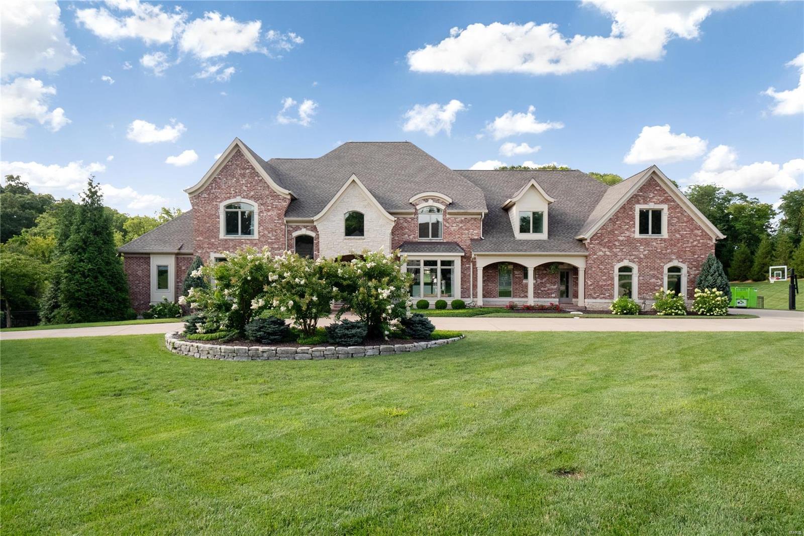 Sitting on 2.5 acres across from Queeny Park, this custom-built home exudes timeless elegance & quiet luxury at every turn. The 2 story entry welcomes you into open foyer & Great Rm w/ fireplace, & large windows. The inviting kitchen incorporates high-end appliances, massive island, & "hidden" walk-in pantry. The adjacent dining area is perfect for family meals & larger gatherings. The kitchen connects to the Hearth Room w/large entertaining area, fireplace, vaulted ceiling, & French Doors to covered patio w/ outdoor kitchen & gorgeous views of professionally landscaped yard. The main floor Primary Suite features enormous bedroom & spa-like primary bath w/ walk-in closets, steam shower & jet tub. Upstairs, 4 large bedrooms, all w/ ensuite baths & custom closets. The lower-level features another Family Rm, guest bedroom, game rm, exercise rm, & a multiuse sports space. The jewel of the home is the outdoor entertaining oasis, w/large, heated pool, expansive pool deck & gas firepit. Additional Rooms: Mud Room