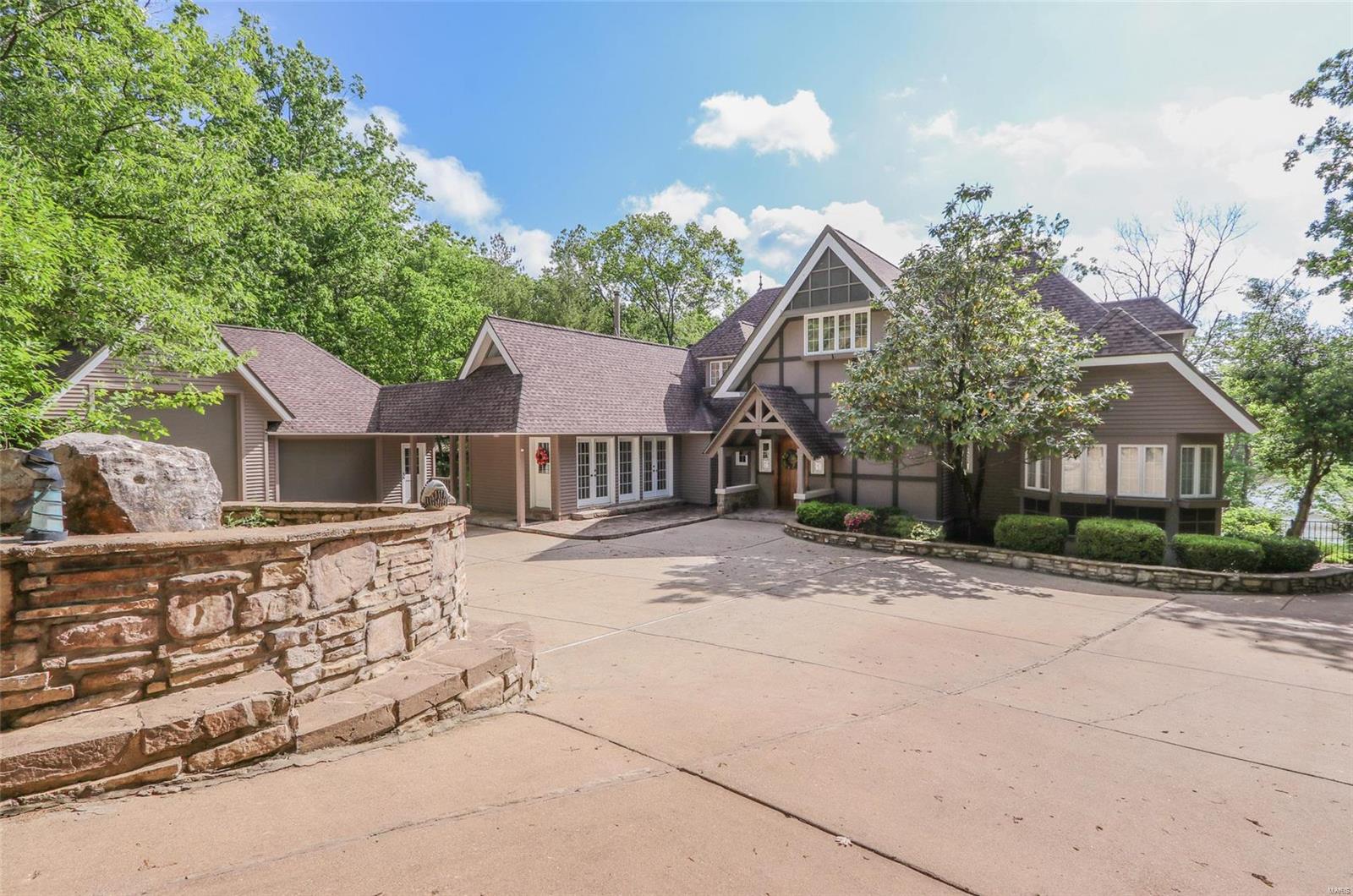 Magnificent estate offering unparalleled lake living at Innsbrook. Tremendous architectural detail and charming European flair. The focal point is the vaulted Grand Hall with hand hewn red oak timber framing, stone fireplace, and loft. The kitchen and cozy hearth room are perfect for intimate gatherings. Large groups will enjoy the massive dining room.  2 beds and bath plus loft are up, master suite on main, and 2 beds plus bath in the LL. A few highlights include 4 fireplaces, solid oak floors, MF laundry, floor to ceiling windows, ample closet space, and geothermal HVAC. Hang out in the lower level rec room, wetbar, and living room. Outside you'll love the inground salt water pool with electric retractable cover. Entertain around the pool, the many patios, gazebo, or large deck. Fish or swim off the private lakeside dock and sand beach. Oversized garage with room for a small RV or multiple cars. Incredibly private 2 acre lot in the heart of the community. Simply amazing. Must see.