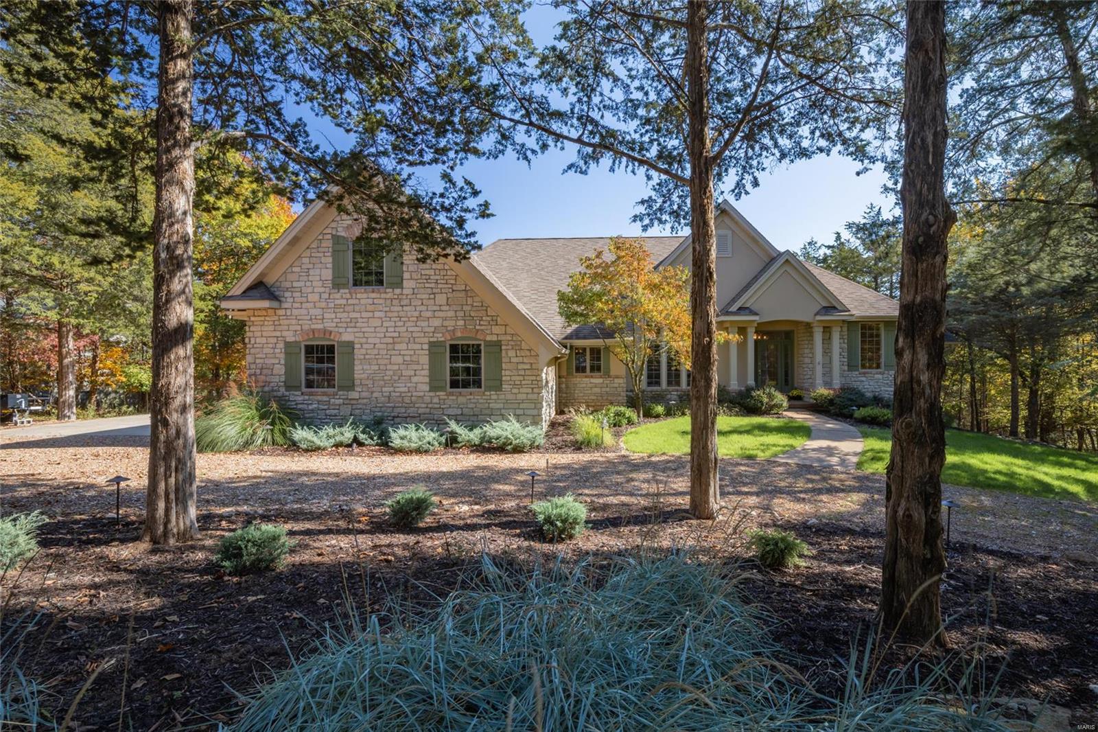 Perched on the shore of Lake Charrette, this premier lake home is ready for the whole family to spread out and enjoy the peaceful woodland vibes of Innsbrook Resort. Split into 2 gorgeous levels of finished living spaces, everyone will be able to enjoy their own piece of paradise comfortably. The main level’s open floor plan boasts a seamless living/dining combo decorated with intricate built-in shelving, hearth room w/ gas fireplace, sunroom, chef’s kitchen, and oversized windows that carry the beauty of the outdoors into every sq ft of the interior. Down the cascading staircase, the lower level offers a great space to entertain with a pool table, wet bar, rec room, gym, 2 additional bedrooms, full bath, and walk-out access to the patio. Once outdoors, enjoy ultimate relaxation on the expansive maintenance-free deck, cast a fishing line off the private dock, or enjoy a cozy fire on the gorgeous lakeside flagstone fire pit.  Come and live your best life in this lakefront dream home! Additional Rooms: Sun Room