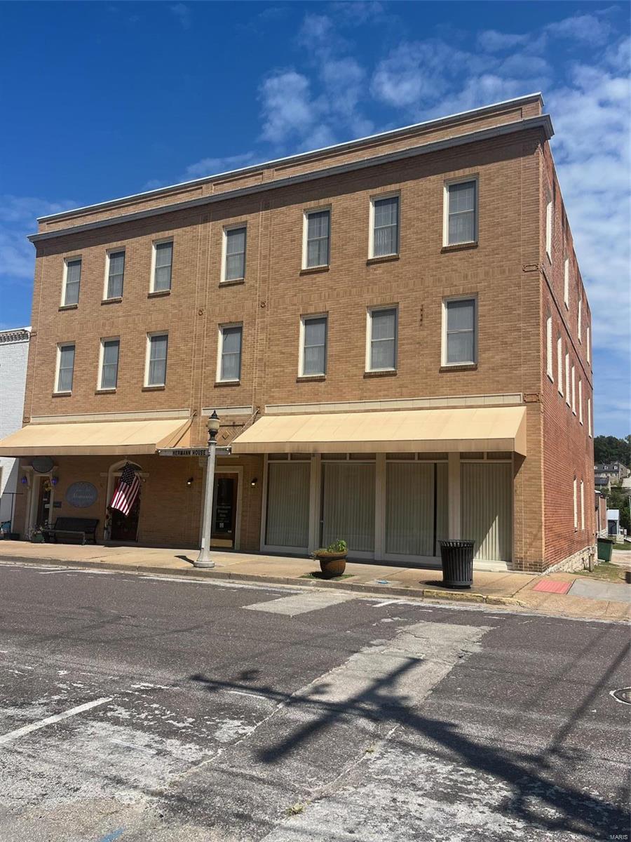 Spectacular Hermann House Inn, in the heart of Hermanns historic district. This property is appox. 10,800 sq. ft.  The main floor consists of 2 storefronts, a large entry foyer, Elevator to all levels, 2 baths & what can be an additional nightly rental unit. (used currently by owners as an office). The 2nd and 3rd floors contain 9 add'l guest rooms all with kitchens & private baths. 7 (1) bedroom & two (2) bedroom units. In the massive basement you will find a geothermal hvac system, main electric panel, sprinkler system, elevator service room & tons of storage. Other features include large parking area at the rear of building plus street parking, access from two city streets & an alley, laundry facilities, wheelchair ramp, & large, covered outdoor patio. Too many highlights to mention. This is a turnkey operation as all guest room furnishing & appliances to convey. This property is a must see. Your chance to get in on the Hermann tourism industry. Duplicate listing of MLS # 24053133.