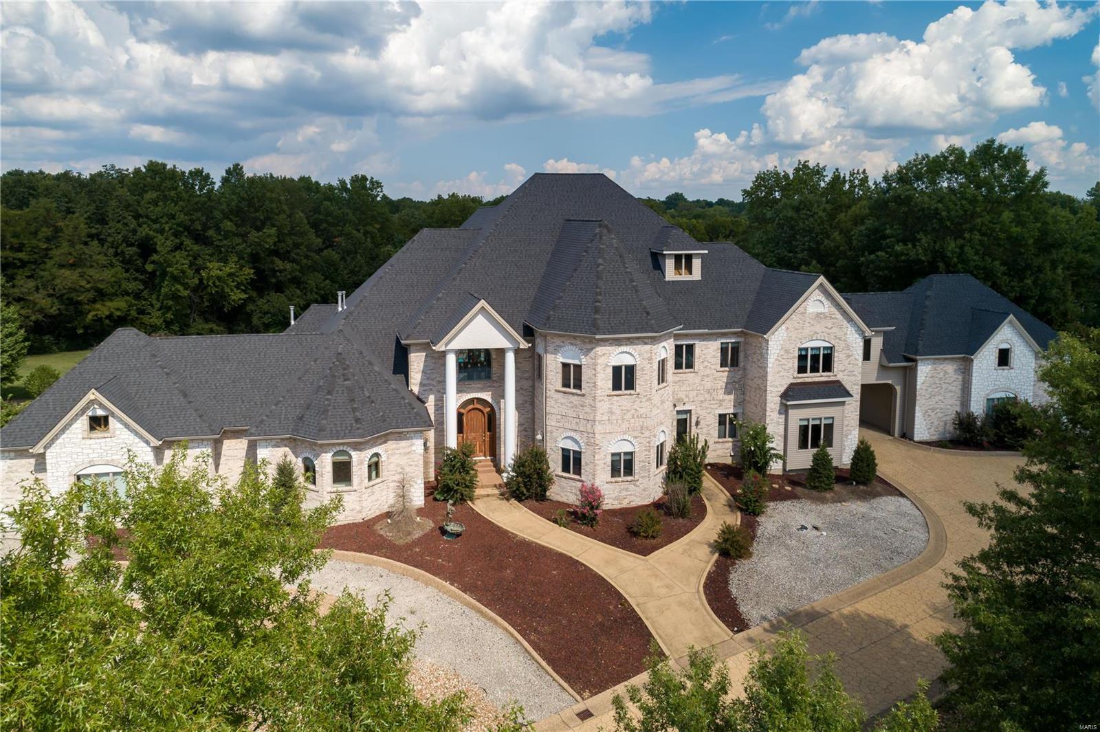 Exquisite details abound in this spectacular property situated on 5+ acres. Built with the highest quality craftsmanship, the home offers stunning woodwork, floating/winding staircase, soaring ceilings, barrel vaults, and main floor master with luxurious bath and sitting room. Large formal dining room opens to two story Great Room. Kitchen will take your breath away with custom cherry cabinetry, granite, built in steam oven and coffee machine, gas cooktop & double ovens.  The kitchen opens to the two story family room that offers direct access to terrace & pool.  Another large main floor bedroom suite adds versatility. Custom bar offers all the amenities for entertaining & the wood paneled office exemplifies sophistication and opulence. Upper level has three bedrooms, two full baths and laundry.  In addition, there is a custom bar, game/rec room and an additional media/playroom. Garage space for 5 cars, two ponds, fountains; this will exceed your expectations. COOL: 14 SEER+