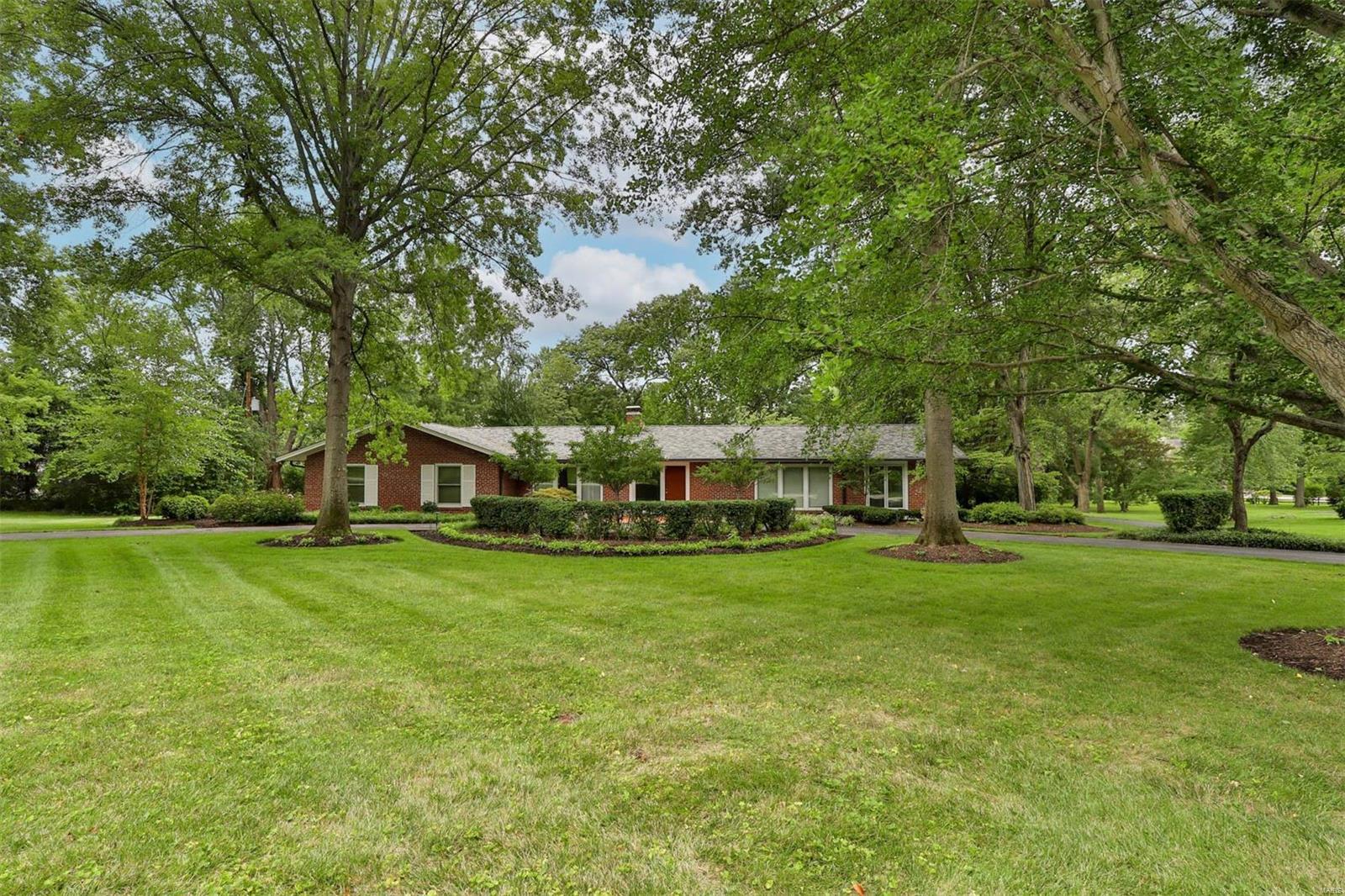 Beautifully maintained brick ranch home situated on 2 flat acres on a private lane in Huntleigh. This is a wonderful opportunity to renovate or build on 2 acres. Fabulous mid century architectural details and a gracious, open floor plan. Main floor features include: Primary Suite, 2 good-sized bedrooms with hall bath, expansive family room with walls of windows, spacious living and dining areas, kitchen with access to patio and lovely views of yard, and a sweet sun porch. Home wraps around private patio. Attached oversized 2 car garage. Clean basement, ready to be finished. The lot is truly exquisite: park-like, flat, plenty of room to add on, install a pool or sport court, and guest house. To be sold as-is, with seller to do no repairs or inspections.