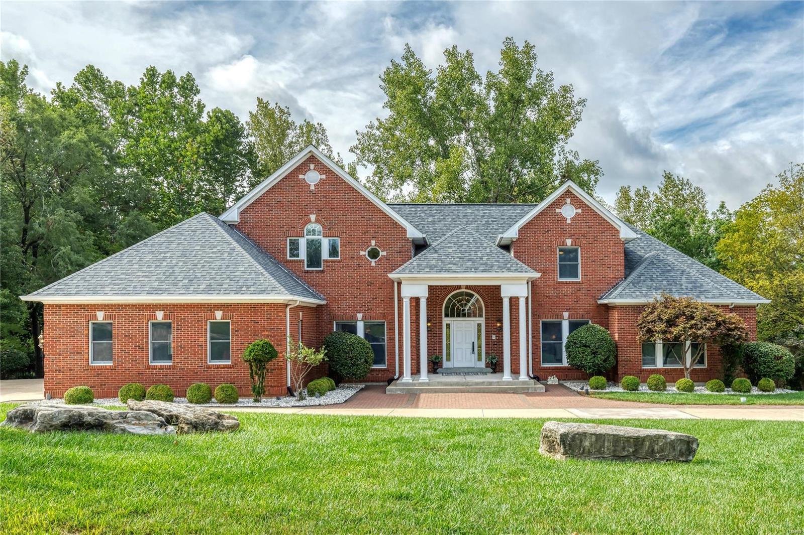 Wow! Circular driveway leads to a rare opportunity to own a home in Town & Country’s coveted Topping Pt. Estates. This is a beautifully maintained home w/ unique features & a wooded private back. A large open foyer welcomes you! Just off the foyer an elegant dining room & living room/study awaits. Gorgeous vaulted great room is accented w/ soaring exquisite gas fireplace. Gourmet eat-in kitchen features granite countertops, wine-cooler, Thermador refrigerator, dishwasher, oversized 6 burners/griddle stove w/double ovens. Spacious breakfast & hearth room is an ideal space for entertaining. MF master suite w/luxury ensuite has custom closet & a private deck. MF 2nd bedroom w/private bathroom is perfect for a nursery or guest quarters. Two large bedrooms suites with baths & walk-in closets on 2nd floor. Basement features spacious rec areas, full kitchen, bar, bedroom, sleeping area & full bath. Zoned Geothermal HVAC, 3 car garage, fenced lot. Close proximity to highway, shopping & more..