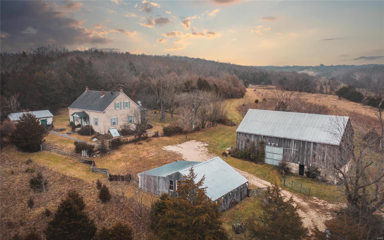 Stoney Hill House in Hermann, MO is situated on a beautiful 205 ac of rolling hills & pasture ground. Located within miles of the historical town of Hermann, MO.  The 4 bed 2 ba home is completely renovated/restored but still has that 1850's feel to it. Original hardwood floors & some old wooden beams built into the ceilings. Currently the farm is used for cattle grazing, hay production, atv riding, hunting & fishing. There's an elaborate trail system throughout & also 3 ponds for fishing. All of the ponds are stocked w/a mix of bass, blue gill, & catfish. The property is fenced & cross fenced w/barbed wire & there is a wet weather creek w/some pools of water in it for wildlife or your cattle. There are also other buildings for tool & equipment storage as well. There are wooden barns & a chicken coop along with a summer kitchen. This farm is the perfect place to hang your hat up at for the rest of your days or would make a perfect weekend getaway. Come take a look before it's too late.