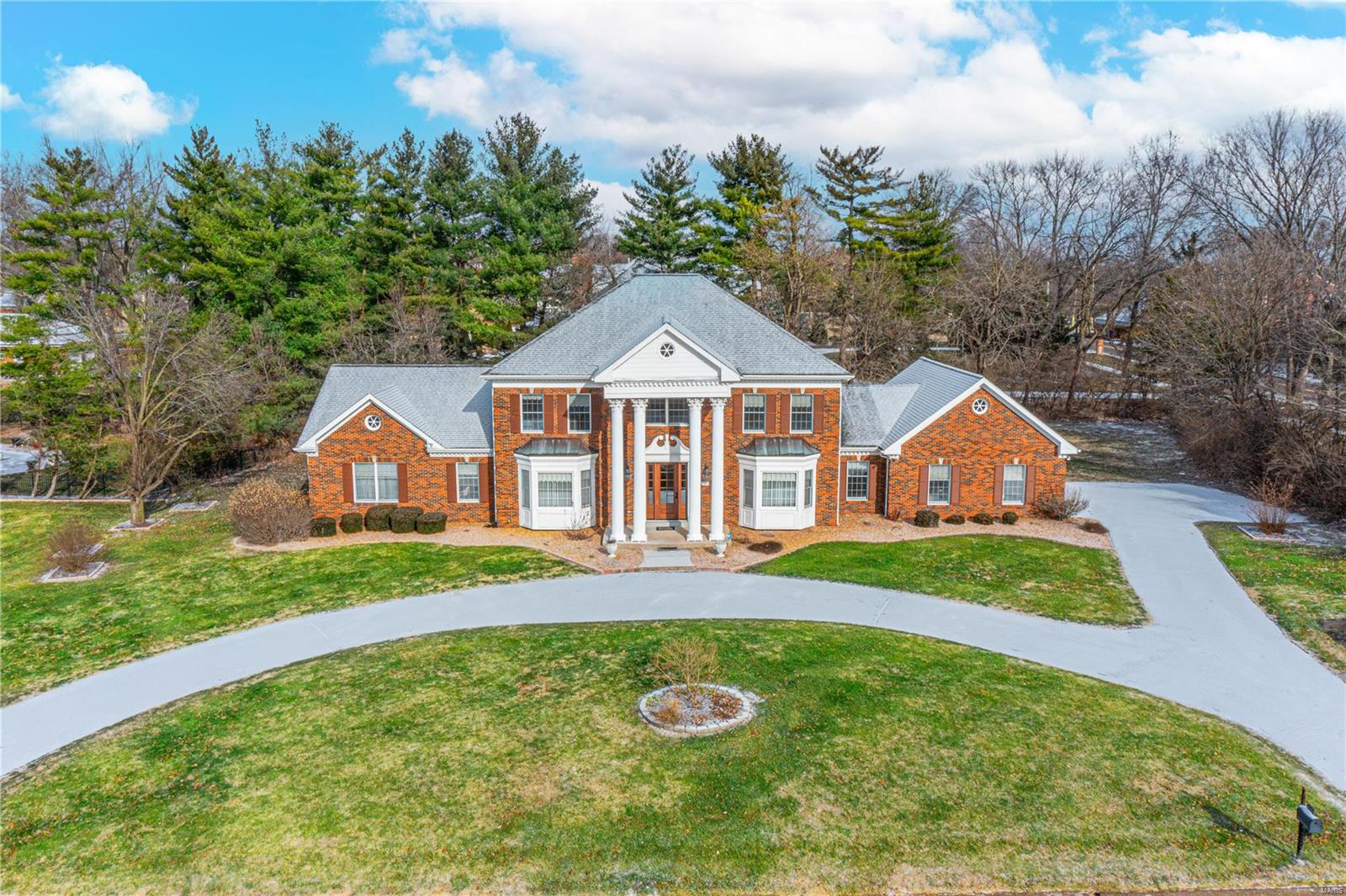 Town and Country at its best! All brick home with Corinthian columns, double bay windows, and a circle drive. The 2-story foyer is beautiful, with a sweeping staircase and marble floors. Formal living room and dining room both with a bright bay window. The dining room has a tray ceiling. On the back of the home is an expansive family room with a fireplace and wet bar. The kitchen features a breakfast room, granite counters, and a center island. Off of the kitchen is a laundry, 2nd powder room, and a storage room. The main floor primary bedroom wing features a wood-paneled office, spacious bedroom, and luxury bath featuring two vanities, a jacuzzi tub, and a separate shower. 3-car, side entry garage. Ready to be finished lower level. Irrigation system. Located close to Straub’s, Queeny Park, and Longview Farm Park. Level backyard!