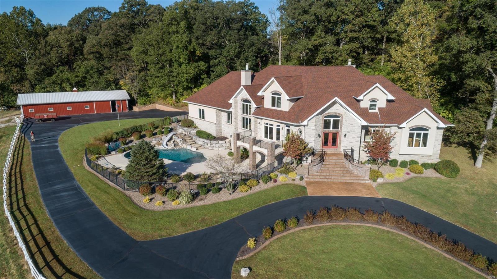 One of a kind 20+ acre "private preserve" rich w/ wildlife & scenic pastures, tucked away yet minutes from shopping, dining & highway access. The grounds offer an in-ground heated saltwater pool w/ waterfall, six stall horse barn w/ additional 4 parking spaces, fenced pastures, lighted riding area & private wooded property line perfect for equine & animal lovers. Stunning home offers many recent updates including remodeled chef's kitchen w/ luxury built-in appliances, new flooring on main & LL levels, two stone fireplaces, extravagant vaults, balconies & custom millwork throughout. Master suite includes off-suite office, luxury bath w/ tiled shower, soaking tub, dual sinks, walk-in closet organizers, coffered ceiling & views of nature. Great room, kitchen, breakfast room, hearth room & dining are ideal for entertaining guests. Finished LL has 10' ceilings, rec room w/ wet bar, game area, private work out room, new media room & full bath walks out to pool. LSL lake & association rights.