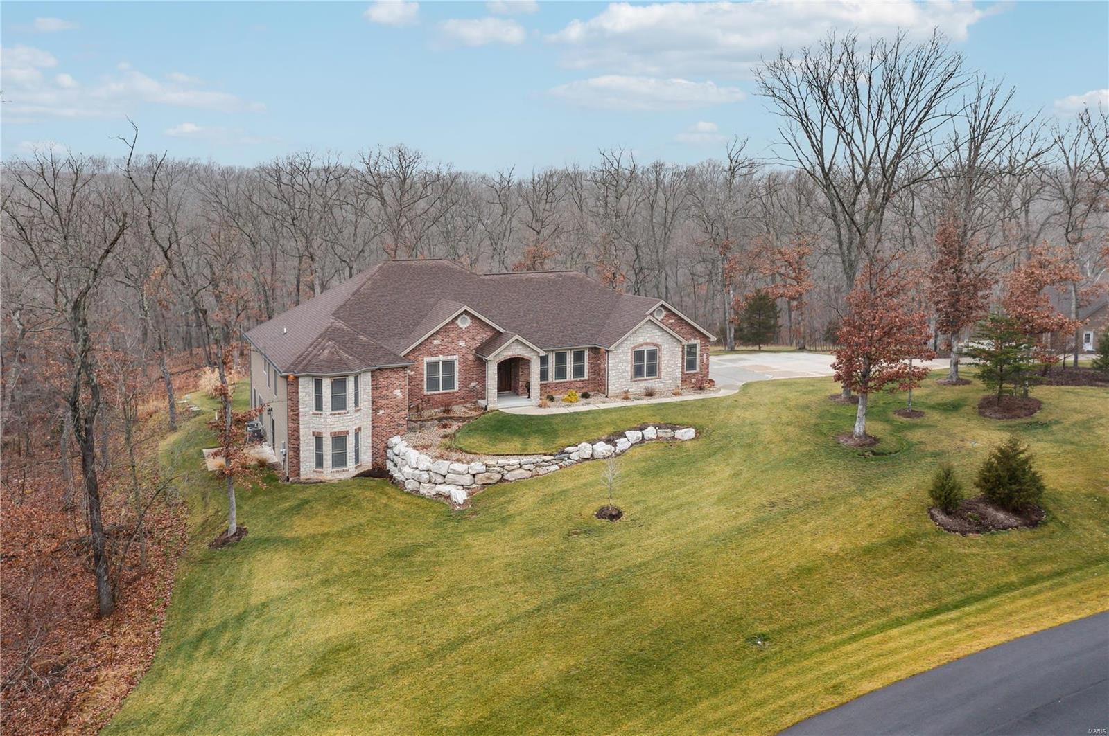 Architecturally-appealing brick/stone façade, 3-car side-entry garage & new, professional landscaping (w/in-ground sprinkler). Recently added detached 3-car garage provides total GARAGE SPACE FOR 6! Attractive front door w/matching side-lights & transom, HW floors thru-out main floor living space & gorgeous wood trim work! Home office features glass French doors, built-in desk/ cabinets/shelving. Spacious DR surrounded by stunning coffered ceiling & beautiful archways. Open floor plan w/gourmet kitchen (stainless appls, stone backsplash, granite counters & huge center island/breakfast bar), breakfast room & great room w/floor-ceiling stone FP & built-ins. Enjoy nature from wall of windows, including transoms & covered patio w/recently added AUTOMATIC/REMOTE SCREENS! Master suite w/coffered ceiling, private door to patio & luxurious bath. 2nd & 3rd beds offer popular Jack/Jill style bath. Walk-out LL is fin. w/huge entertaining area, gorgeous wet bar, 2 add'l bedrooms & full bath.
