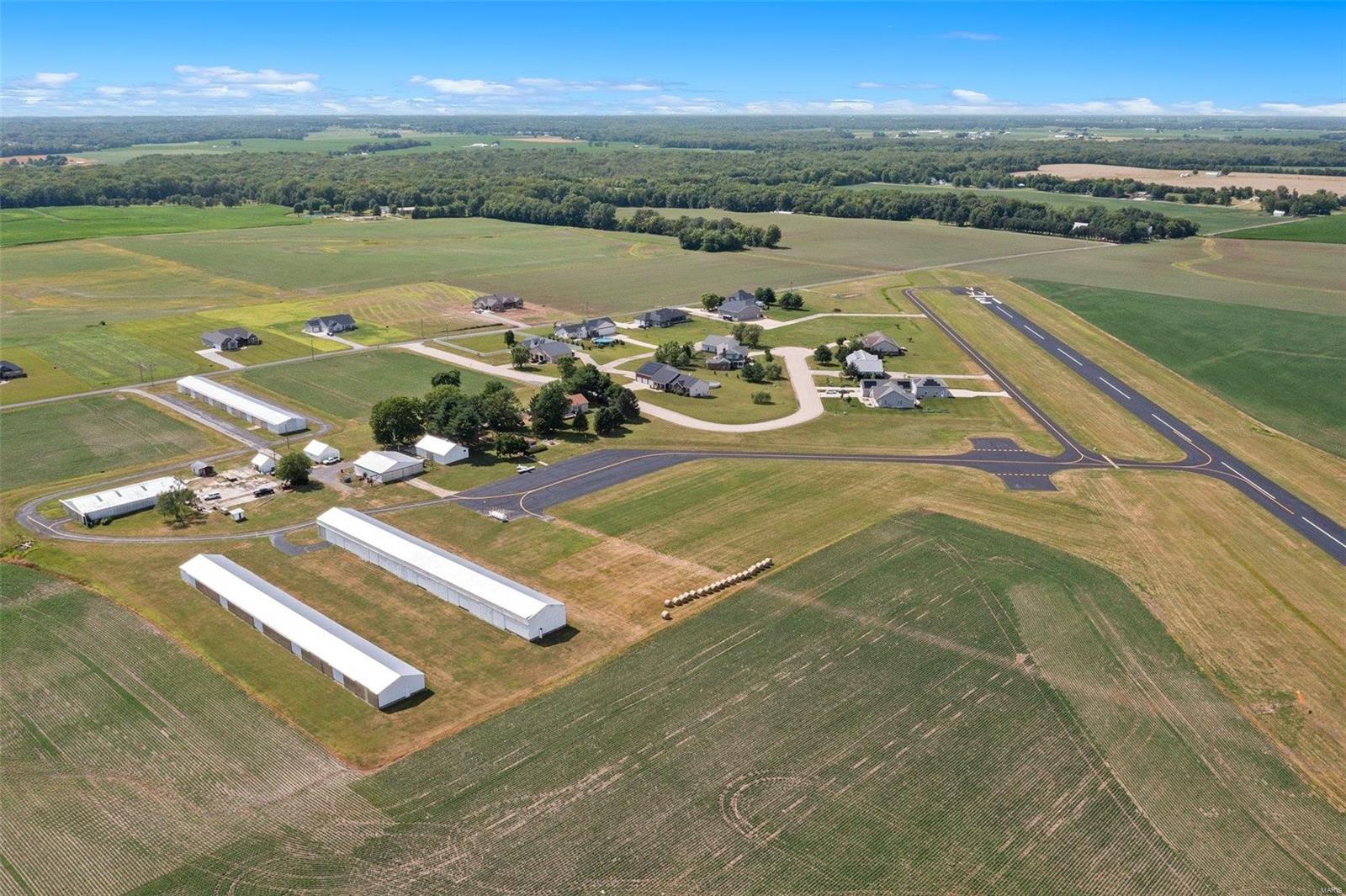 St. Louis Metro East Airport has been a functioning small aircraft private airport for over 45 years. It sits on 33.75 acres & has 3 large storage hangars all roughly 10,000 Sq Ft w/10 airplane pads in each hangar, a maintenance hangar of nearly 3,000 Sq Ft, a shop, an office, garage, and a maintenance building with classrooms and a small apartment. Estimated total asphalt area for taxiways and runways is approximately 203,000 Sq Ft.  It sits just 2 miles off I-70, under 1 mile to Highway 40, and just 25 miles from downtown St. Louis. 3 bed, 2 bath home on just over 3 acres overlooking the runway of St. Louis Metro East Airport. Relax on the back porch and watch the planes come and go. This home features an open floorplan with a large kitchen island, dining room and living room with a gas fireplace. It boasts 9ft ceilings and a full unfinished basement just waiting for your touch. Location: High Traffic, Hwy/Interstate Frntg, Rural