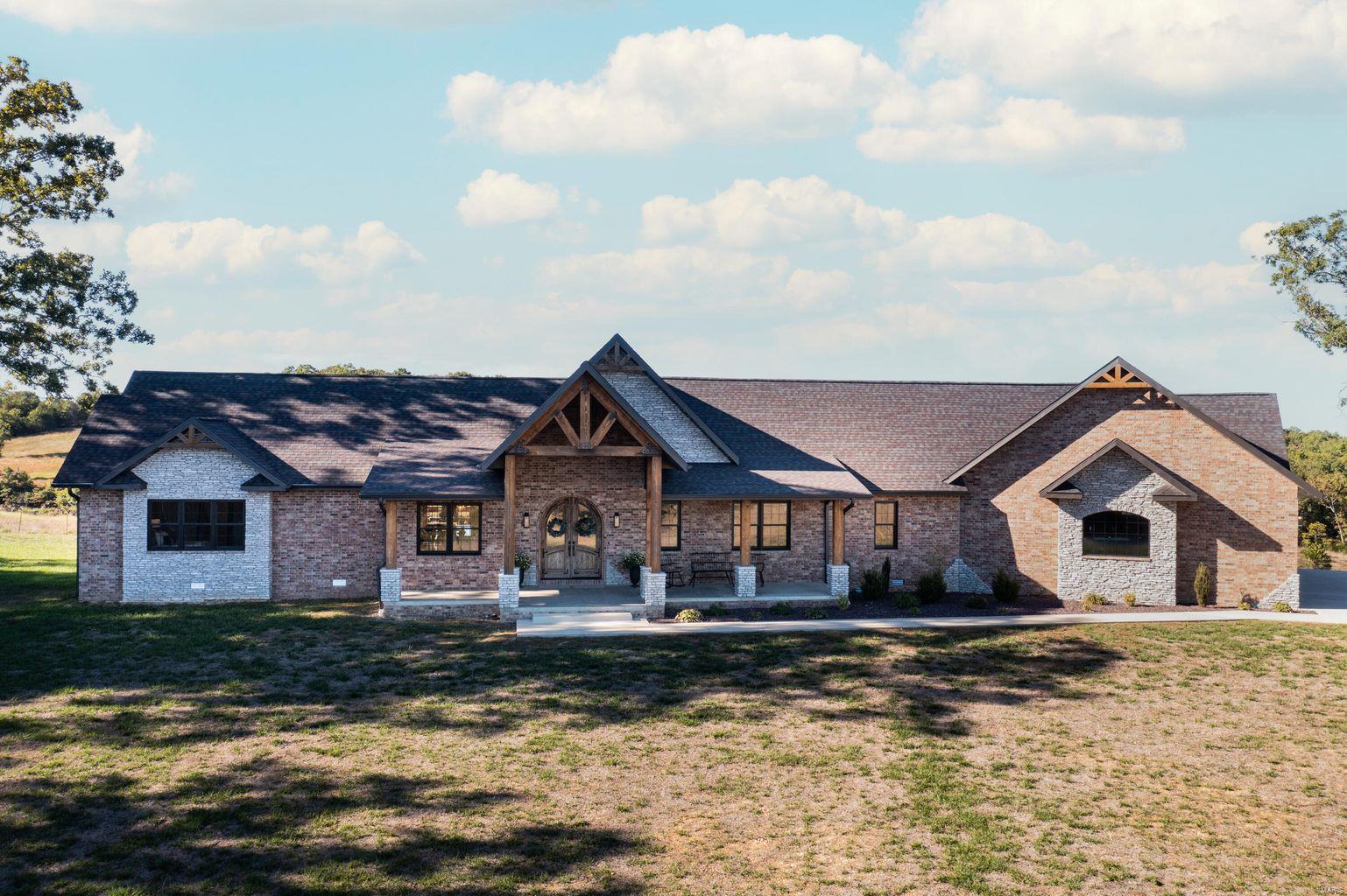 Custom Brick Home w/ stone accents & timbers! 4 Bedroom, 4 full bathrooms, & 2 half bathrooms - Custom cabinets w/ granite counter tops. Walk in Pantry-walk in closets for each bedroom-stone fireplace-hand constructed timbers-custom hardwood floors & tile work-home built with a 12/12 pitch for large vaulted living room & master suite-stainless steel appliances in kitchen w/ large island-floating concrete back porch-finished partial basement offering gun vault room w/ vault door, full bath, John Deere room, storage, additional living room & electrical/mechanical room. HVAC is state of the art GEOTHERMAL system w/ parts & labor warranty-2 small barns-state of the art cattle working facilities-catch pens w/ waterers-spring fed pond-other smaller ponds-huge deer stand in the middle of cut out food plot w/ shooting lanes. Large deer & turkey. Entire property is perimeter fenced, w/ piped corners, & large piped entryway-cross fenced & woods are fenced out. Property offers marketable timber.