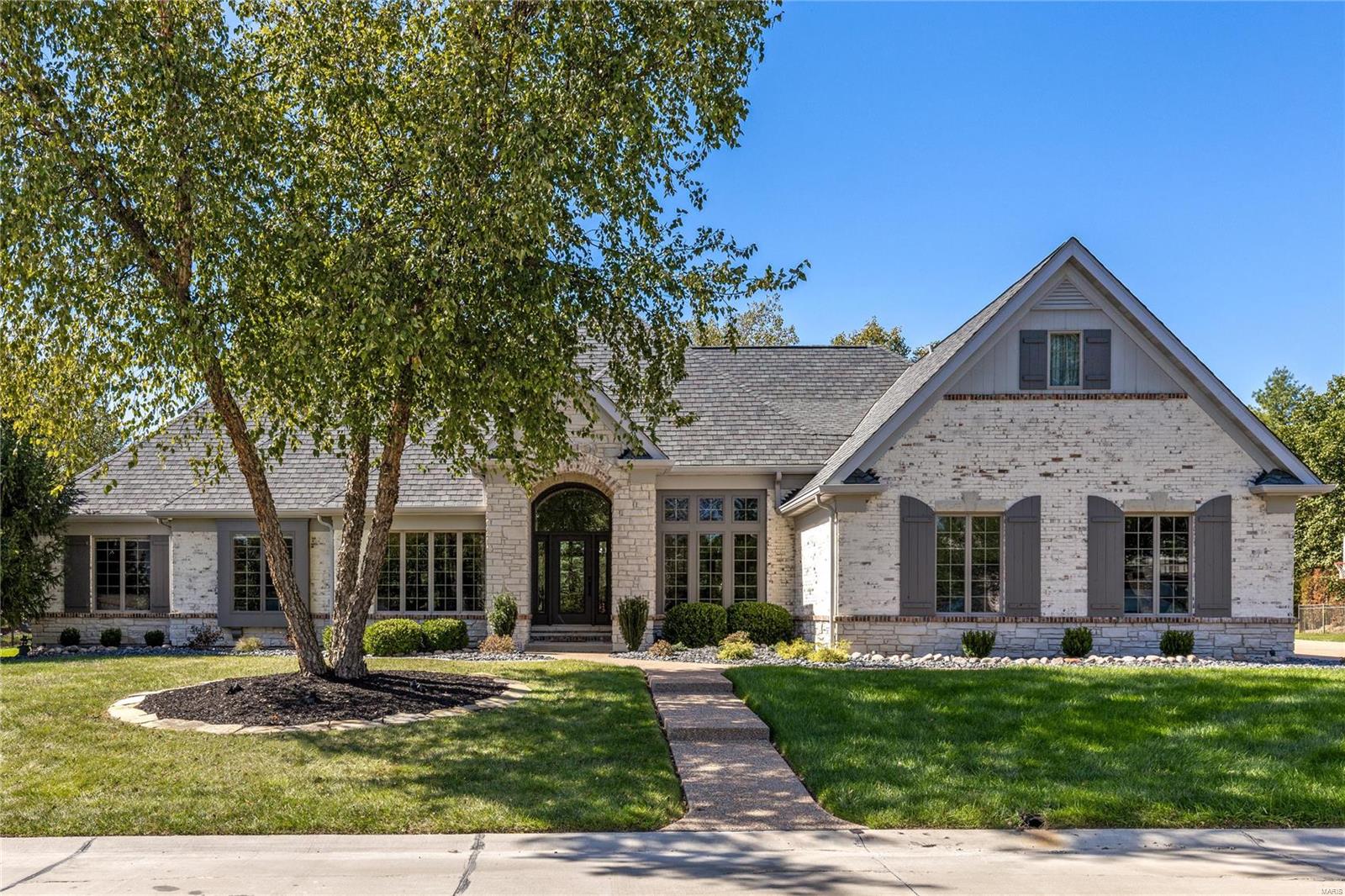 Spectacular brick & stone great room ranch from award-winning Schaeffer Homes. Open floor plan features 12’ ceilings, detailed trim work & handscraped hickory flooring that extends throughout the main living area. Impressive hardwood foyer leads to private study, formal dining room & stunning great room with box beam ceiling, brick fireplace flanked by built-in bookcases & bank of windows. Designer kitchen features glazed cabinetry, granite countertops, premium appliances & 5’ center island with adjoining dining table. Primary bedroom suite with luxury bath with shower spa plus 2 additional bedrooms & hall full bath complete the main floor living quarters. Lower Level includes recreation room with entertainment center & wet bar, gathering bar, office, workout room & full bath. Situated on parklike .74-acre grounds with outdoor living room, patio with grilling station & full-height fireplace & resort style pool with waterfall plus 2-car garage & detached garage with bonus room & ½ bath.