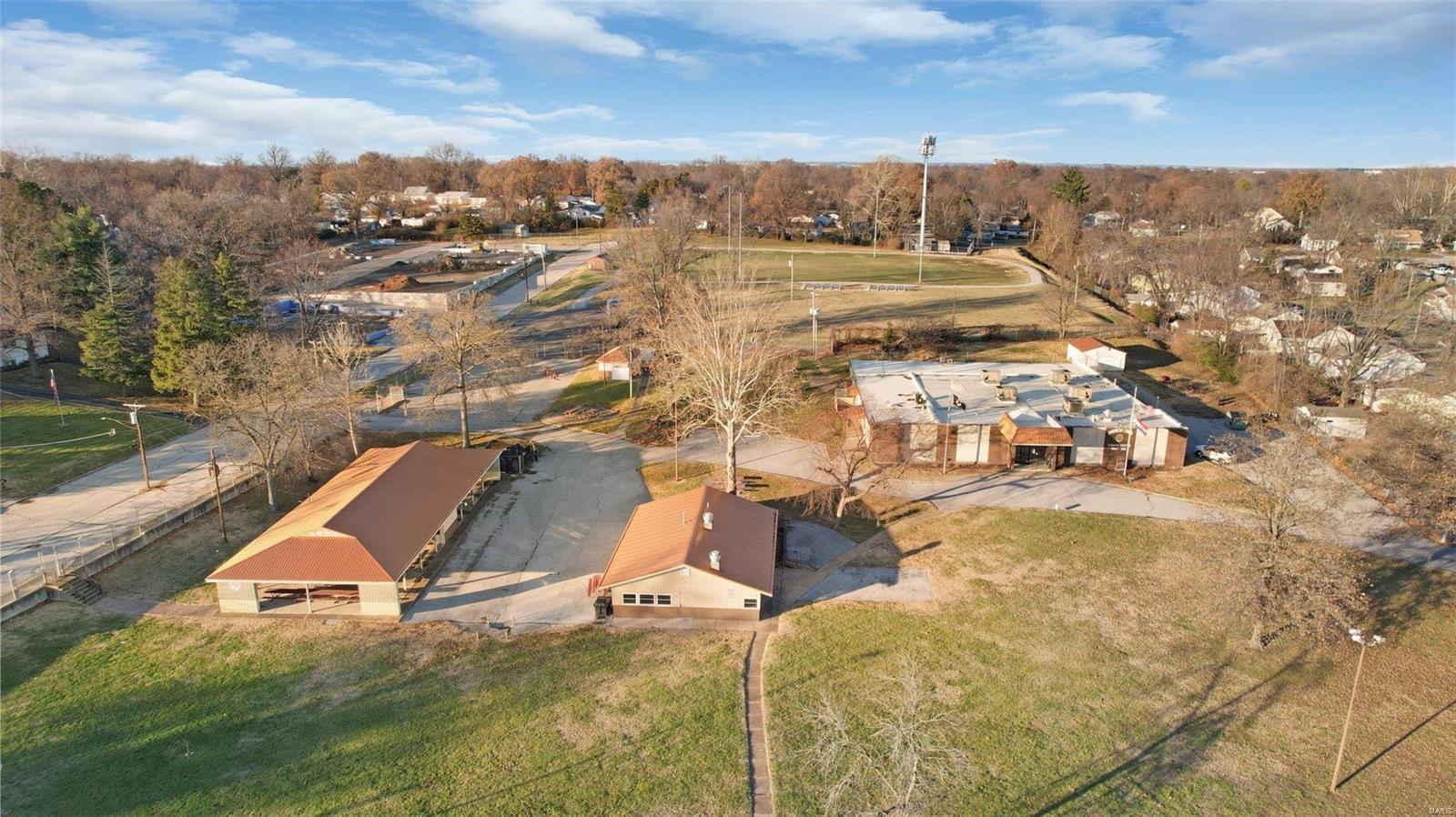 A Historic Landmark in Overland Missouri, Thoman-Boothe Post 338-American Legion Hall, is a fantastic opportunity for someone to  invest in a versatile property! Multiple buildings include an event center with over 13,000 sqft and capacity for 300, you'll find a large commercial kitchen, two bathrooms, office space, game lounge with private bathroom and tremendous storage. The 4.13 acres also includes a 2000 square foot building currently used as a concession/food service facility, a 5000 square foot pavilion with a concrete floor and newer metal roof. The grounds contain a separate garage for storage as well as a small building with men and women's restrooms. The entire 4.13 acres is fenced. Parking exists along Midland Blvd, a separate parking lot off of Angelo Avenue. There is an additional 1/3 acre available. So many possibilities for this property, with easy access to Lindbergh BLVD and Highway 170. Furniture, Fixtures and Commercial Kitchen Equipment may be available for sale. Some Accessible Features Location: City