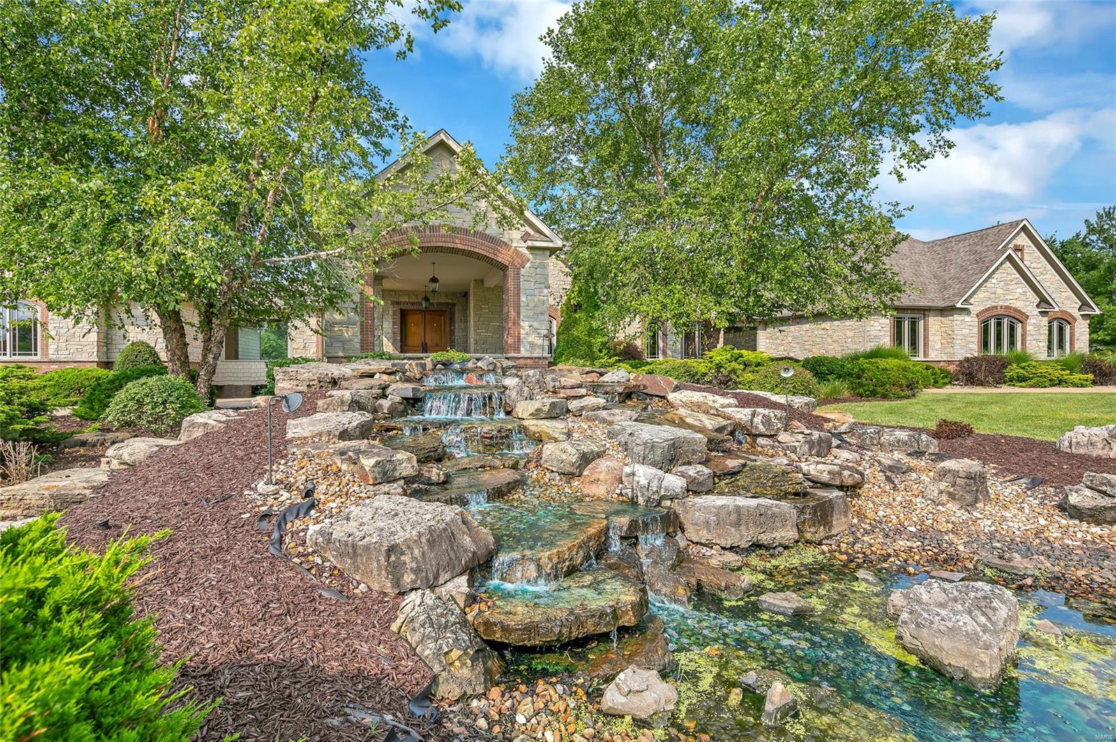 Luxurious country estate just west of suburban St. Louis in the secluded and all natural SW St Charles County - stunning raw beauty. Situated on the premier lot in August Estates, this sprawling ranch is magnificent! From solid Brazilian walnut flooring, to hand carved newel posts complete with contrasting inlaid wood, to the meticulously turned semi spiral staircase - no detail spared to achieve craftsman ideal. The incredible gourmet kitchen wows guests, while the butler's pantry and secret full bathroom are a host's dream. A glass enclosed walkway bridges the north wing to the south wing/bedroom suites. A pretty stroll! Master suite is a total sanctuary. The private south wing lower level is a large unfinished walkout space with all systems in place, full bathroom rough-in, ideal for bath house or separate quarters. 8 car garage and motor court, grand circle drive and porte cochere. 3 gorgeous acres, amazing yard. Newer roof, newly updated septic, the list goes on! Excellent home. Additional Rooms: Mud Room