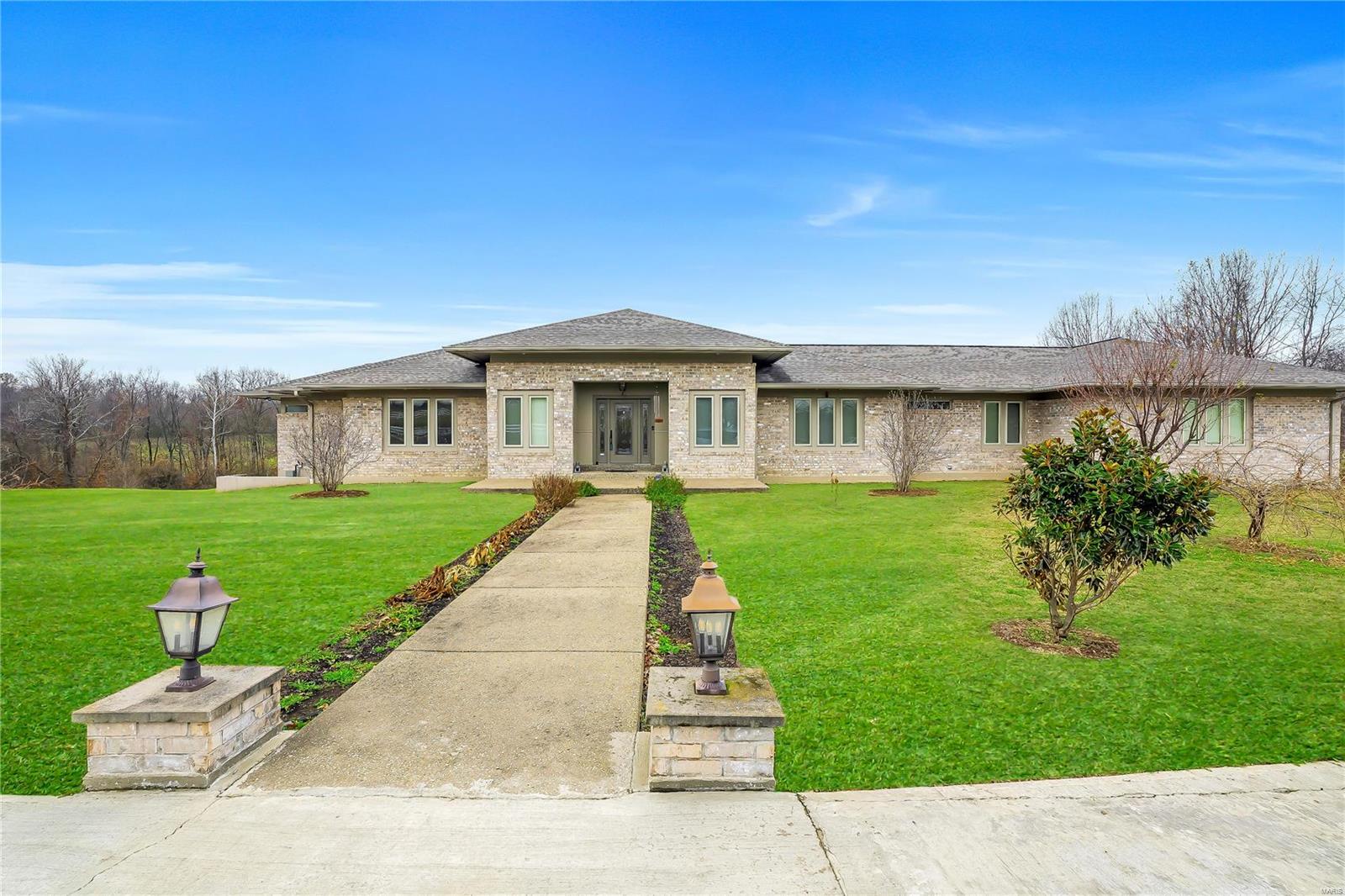 Indulge in luxury with this 6600 sq ft ranch on over 10 acres featuring 5 beds and 6 baths. The open floor plan, adorned with coffered ceilings, seamlessly connects to a huge custom kitchen, complete with a large island. A 3-car garage and circle driveway provide ample parking. The finished walk-out basement, including a wet bar, enhances entertainment possibilities. Enjoy the convenience of walk-in closets and walk in pantry. Outside, a Hardie board and brick exterior complement the charm, while the equestrian farm offers a large barn, expansive workshop, and a grand outdoor riding arena. Live in opulence with every detail meticulously crafted for your comfort and enjoyment..