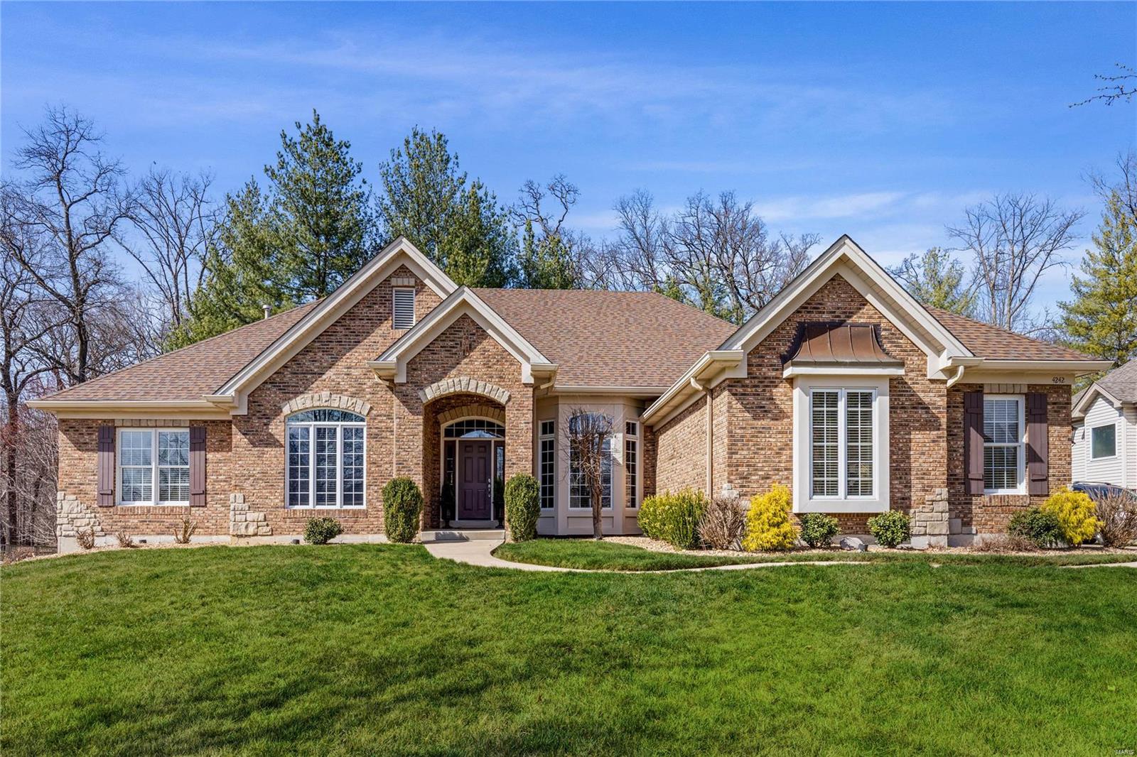 Outstanding brick & stone-crafted ranch home from award-winning Cross Custom Homes. Open floor plan features oak hardwoods, 11’ ceilings & detailed trim work. Impressive hardwood foyer leads to private study with French doors, formal dining room and stunning great room with scalloped entryways & dramatic wall of windows that overlook wooded ground.  Designer kitchen with 42” cherry cabinetry, granite countertops, premium stainless steel appliances & center island adjoins breakfast room with convenient planning center & hearth room with groin vault ceiling & floor-to-ceiling brick & stone fireplace. Coffered primary bedroom suite with wide bay window, 2 walk-in closets & luxury bath offers an appealing retreat. A 2nd ensuite bedroom completes the main floor living quarters. Lower Level entertainment space includes recreation room with fireplace, gathering bar, 3rd & 4th bedrooms & full bath. Situated on an extensively landscaped .8 -acre lot with bi-level paver patio & 3-car garage.