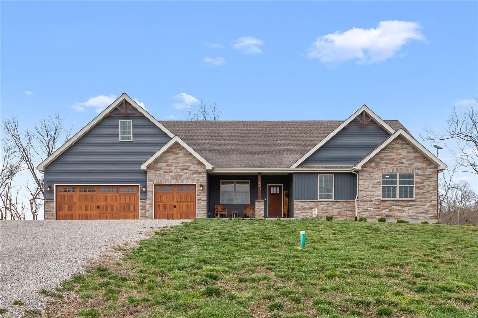 Stunning 2 year-old ranch on 10 scenic acres in Defiance with access to a serene 12-acre lake! Located in top-rated Francis Howell schools, this 2,285 sqft home blends refined style with modern luxury—featuring an open floor plan, soaring vaulted ceilings with wood beam accents, Luxury Vinyl Plank floors throughout the main living area & a striking see-through stone woodburning fireplace. The gourmet kitchen impresses with a large center island, gas cooktop, wall oven & walk-in pantry. The spacious primary suite offers coffered ceilings, a spa-like bath with an oversized tiled shower & a generous walk-in closet. You'll also find 2 additional bedrooms, a home office, 2 full baths, a half bath for you & your guests, & energy efficient geothermal HVAC. Step outside to a stamped concrete patio & spa-ready pad—perfect for entertaining. The 7,200 sqft outbuilding is a RARE find, featuring 400-amp service, bath rough-in & radiant heat-ready floors. A true lifestyle property-don't miss out!