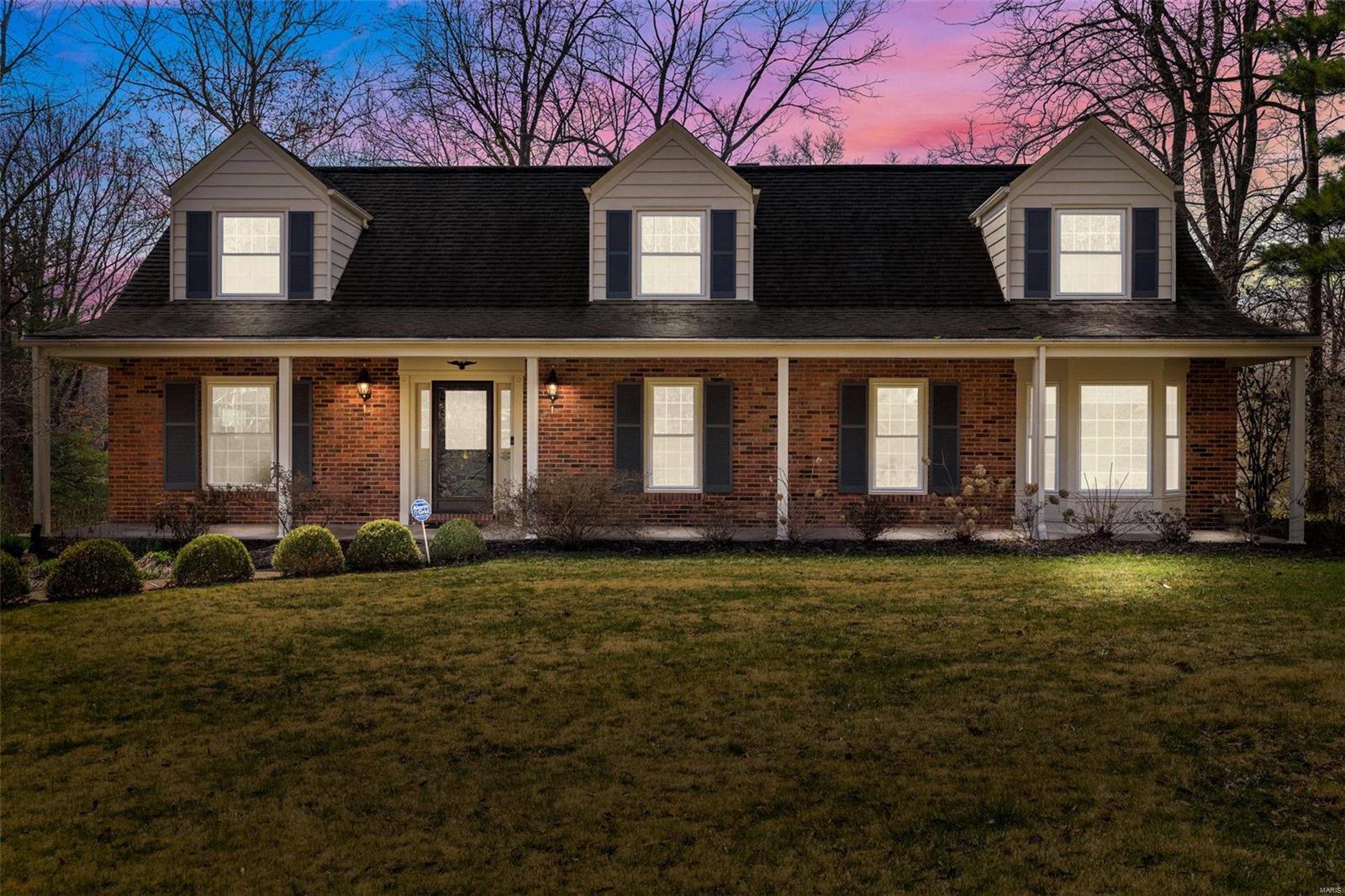 Located in Ladue, 9830 Wild Deer is a spacious 3,042 sq ft Cape Cod style residence featuring 4 bedrooms and 3.5 bathrooms. This home has undergone significant updates, including modernized kitchen and bathrooms, some newer floors, roof, HVAC, windows, and deck. A large covered porch graces the front.  The foyer leads into a large formal living room and a dining room with bay window. The kitchen is highlighted by custom cabinets, soapstone countertops, stainless appliances, two appliance bays, a large peninsula with wood countertop, and plenty of storage. The kitchen opens into the family room with built-in bookcase, wet bar, and fireplace. The sunroom features floor-to-ceiling windows and heated floors and leads to the deck. The main level also has a primary bedroom and a bath with heated floors. The upper level has a large ensuite, two additional bedrooms, a guest full bathroom, bonus/office area, and a large walk-in closet or 5th bedroom. Superb landscaping. Rec area in lower level. Additional Rooms: Sun Room