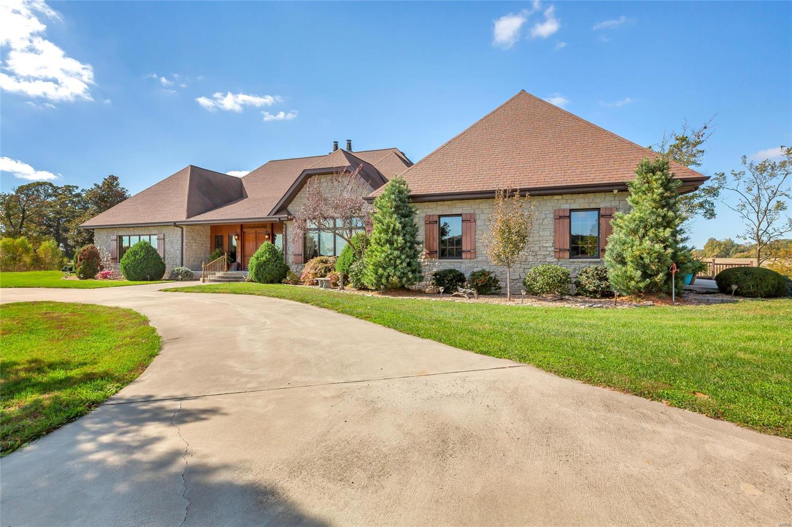 Impressive ranch home nestled on 21.93 scenic acres including a lovely lake! As you approach note the great curb appeal offered by the extensive landscaping & covered porch. Step inside to find gorgeous cherry wood & porcelain tile flooring throughout the common areas. The family room features crown molding & gas fireplace. The kitchen boasts a large center island, quartz counters, & ample cabinet storage. The master bedroom suite features huge His & Hers closets, deck access, & attached master bath w/ tub & separate shower. Also on the main level find the formal dining room, laundry room, half bath, & den w/ built in desks & shelving. Take the elevator to the lower level to find the sprawling family room w/ wet bar & fireplace, theater room, sitting room, 1/2 bath, office, bedrooms 2 & 3, bonus room, & Jack & Jill bath. Also noteworthy is the amazing outdoor living area w/ huge patio & deck.