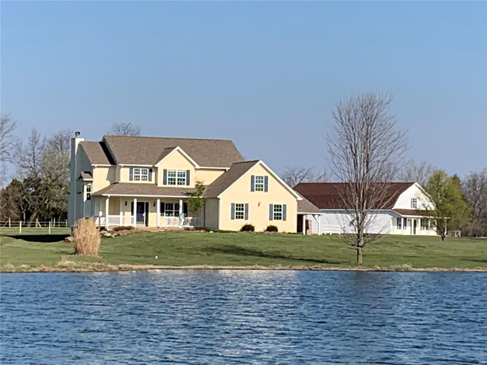 LAKE FRONT CUSTOM HOME overlooking 4 acre lake just 3 miles south of the Foristell exit all on 37 acres. This home boasts over 4,000 sq ft of living space with spacious rooms & lots of natural light. The kitchen is equipped w/a walk in pantry, under cabinet lighting, granite counter tops & a built in steaming table in the kitchen island. A marble gas fireplace located in the family room is sure to keep you warm on those colder nights. Enjoy the sunroom & back patio w/a pavilion & outdoor fireplace next to the inground heated pool this summer or on the front porch in the evenings to enjoy the view of the lake.  Additional "shouse", horse barn, and over 30 acres of open fields and pasture are just a few of the highlights. A beautiful oasis awaits you! Come see for yourself! Additional Rooms: Sun Room