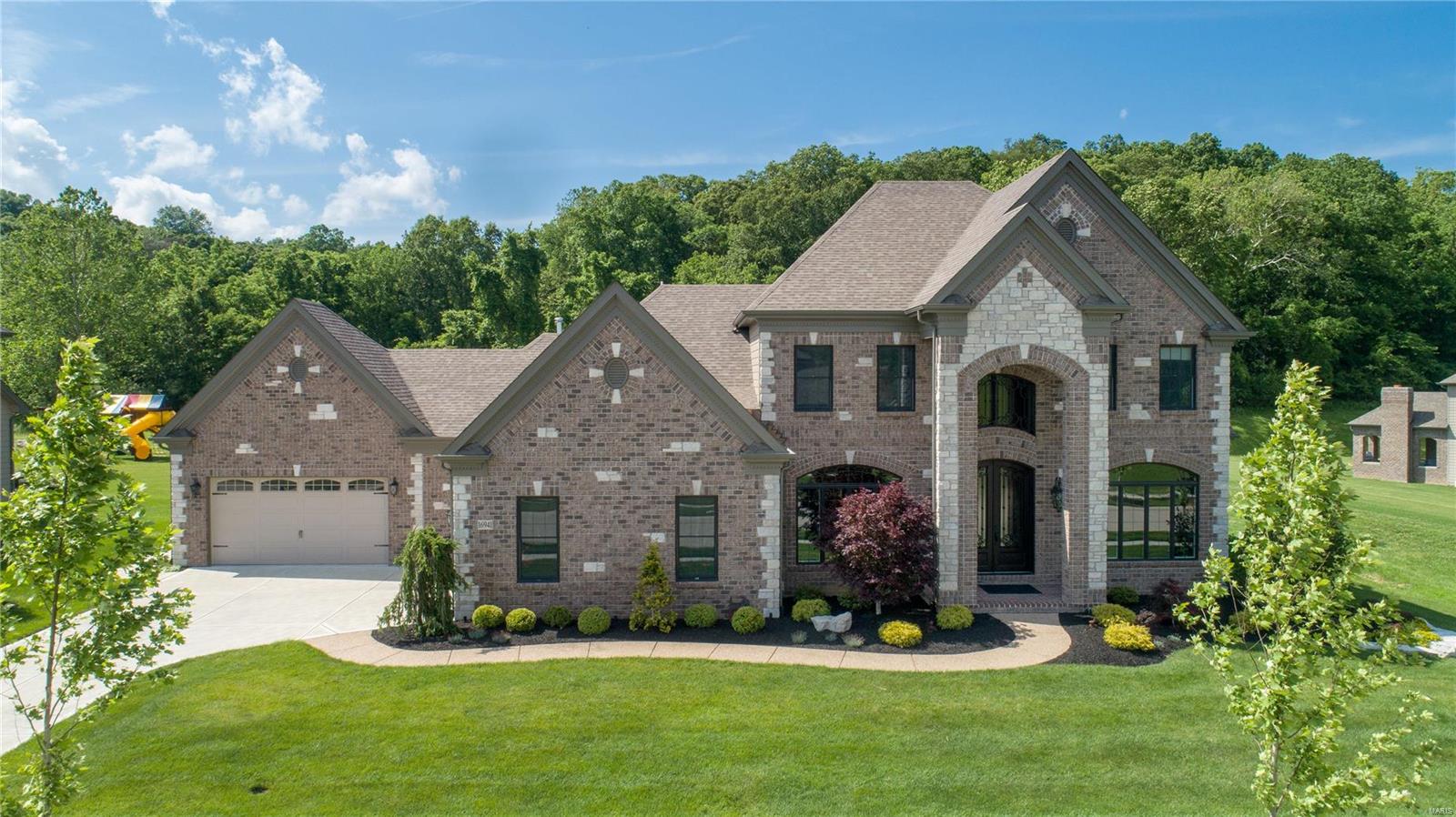 Why wait to build! Incredibly large level lot backing to trees! Gorgeous custom home by Claymont Development showcasing the builders signature masonry work both exterior & interior including a custom finished lower level offering over 5000 sq ft of finished living space & covered patio with fireplace and open patio; 2 story entry with marble flooring; Wide plank handscraped hardwood flooring throughout. 2-story great room with awe-striking wall of windows, stone gas fireplace & built-in shelving; Gourmet kitchen features massive center island/breakfast bar, walk-in & butler’s pantry, Theramador SS appliances, granite counters & crisp white cabinetry w/ crown molding; Spacious main floor master with luxury bath; Upper level offers three large bedrooms, one with private bath & one jack-n-jill bath; Finished lower level with spacious rec room highlighted by brick & stone bar, sleeping room with private bath and walk-in closet, media room.  Plenty of storage QUICK CLOSING NOW AVAILABLE Additional Rooms: Mud Room