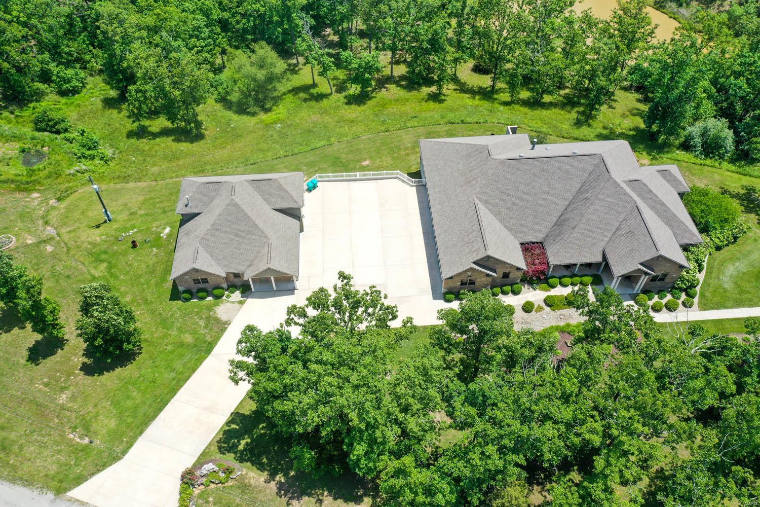 WOW is this place incredible. This is a show stopper of a house on 17 beautiful wooded acres. The owners spared nothing when building this home. There is about an acre stocked lake. There is a large separate brick garage and RV garage with office and 1/2 bath that is fantastic. The property is beautifully landscaped. There are so many updated and incredible features in this house that you forget that you are in a beautiful and fun small town surrounding. The internet is high speed fiber optic. Lots of concrete if you have a car collection. This house and property has everything that is needed to bring on the AWE factor. Wood floors, custom cabinets, special countertops, Anderson windows every special feature is in this house. Some Accessible Features