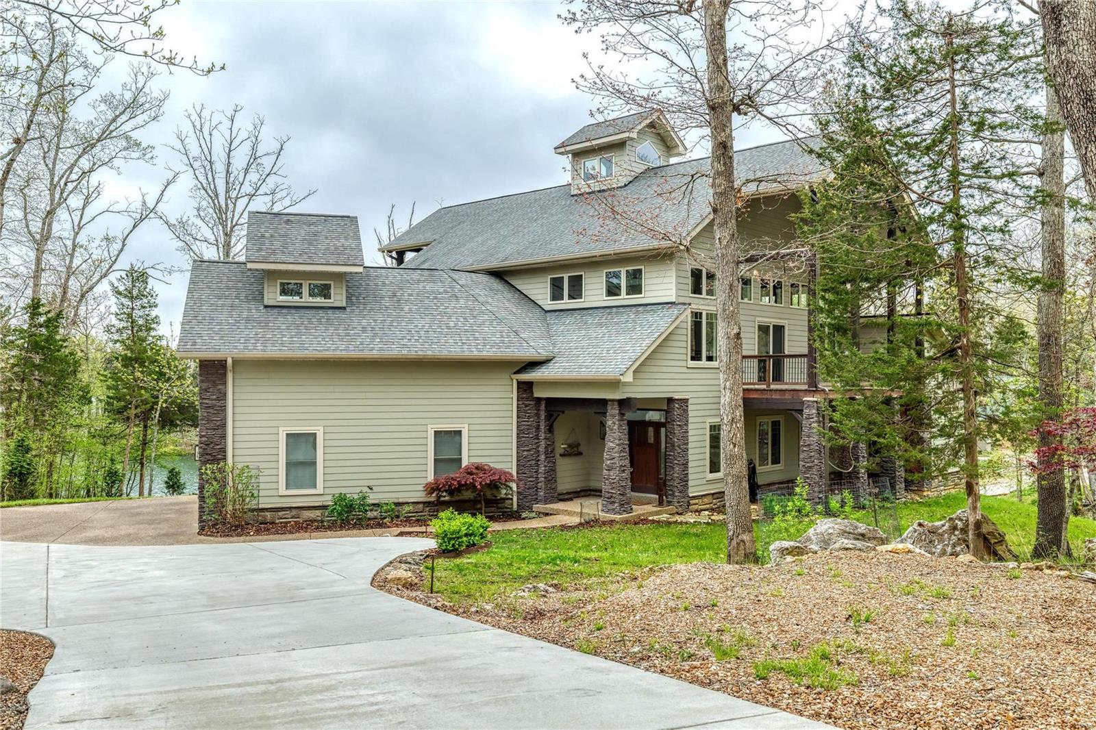 This magnificent one-of-a-kind vacation or permanent home sits waterfront on Lake Alpine w/a beautiful shoreline. The view of the 200+acre lake is just the beginning of what makes this home spectacular. Each detail has a story, from the architectural style which was patterned after barns of the Midwest to the reclaimed wood floor and custom loft railings. Fireplace designed from copper & muntz metal; open floor plan with stunning gallery view makes this the perfect home for entertaining. The 2.3-acre lot features a walking sculpture garden by renowned artist that stays w/the home; spend your days on the dock to soak up all of the summer ahead. Features inc main level primary suite w/fireplace; gallery loft with guest suite; 3 levels of deck/patio; Mosler safe room; geo-thermal system for max efficiency & low utilities; stainless steel chef's kitchen; walkout LL w/bedroom, bath, large rec room, fireplace; oversized garage for RV or boat. This home is an artist-inspired must-see!