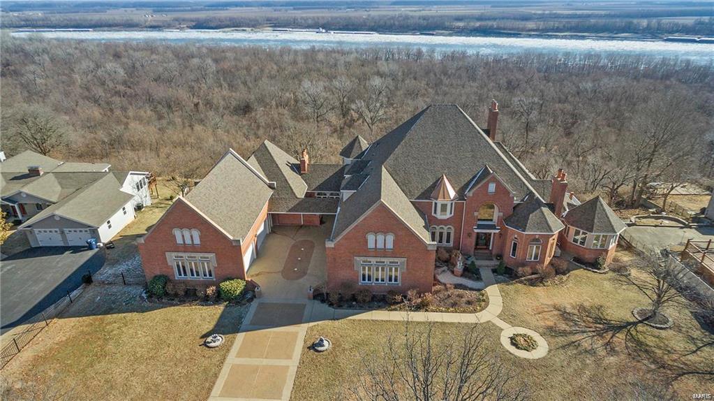 Extraordinary estate over 14,000 SF of lavish living space offers 5 BRs & 5.5 baths and a widow’s walk providing a panoramic view! All 4 levels offer breathtaking views of the Mississippi River and hundreds of acres of nature at its finest! Truly custom built home featuring distinct finishes that all seamlessly flow together in this luxury home. Exquisitely finished with handcrafted millwork, Italian marble, soaring ceilings, strand woven bamboo flooring (2017), flawless brick & stone, high-end appliances and endless entertaining options, including a 25-seat theater and a full 50’s Diner! Warm with charm, elegance, multiple fireplaces and geothermal heating! Grand main floor master sitting room & spa en-suite both providing panoramic views! Partake in an elevator ride for three levels when desired. Motor court flanked by two 4-car garages! New Architectural Roof, 2017 Enjoy an unforgettable viewing of the St. Louis July 4th aerial displays! Quiet country life with quick city access!