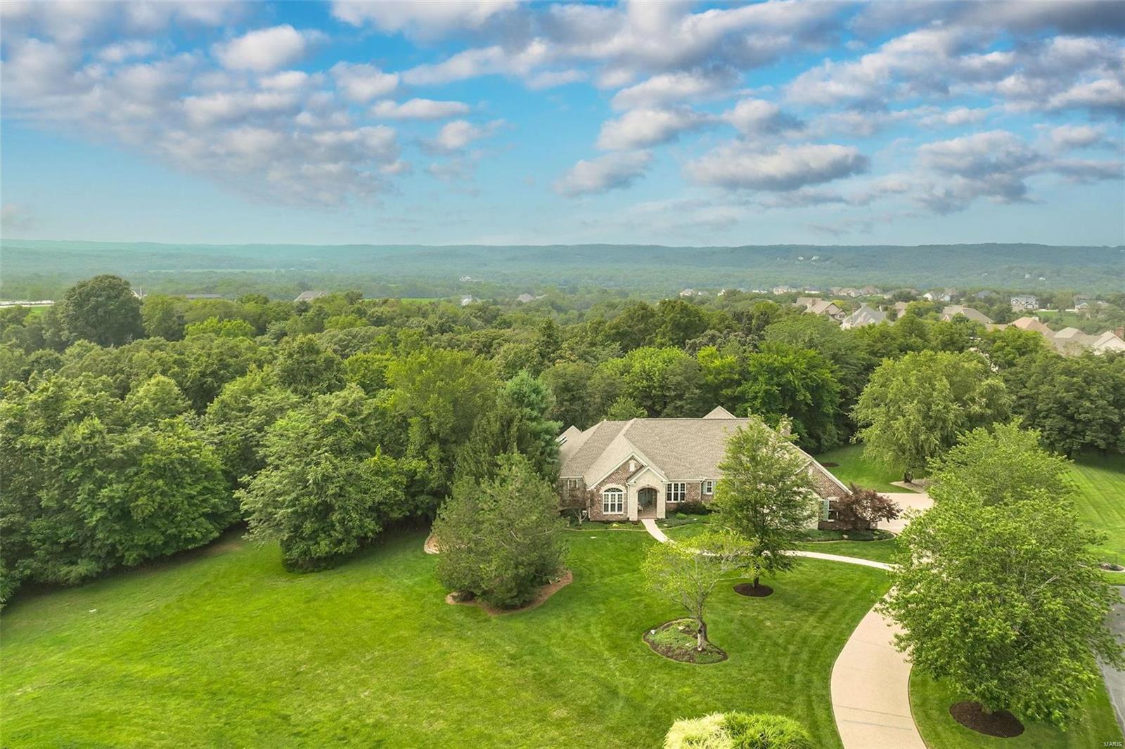 4,350 SF of CUSTOM-BUILT perfection! Just 2 minutes off Hwy 44 to live in peaceful surroundings with privacy and seclusion. This stunning inverted 1.5 story sits on 3 ACRES surrounded by 3 golf courses-- 20 min to Clayton, 30 to downtown.  The attention to detail throughout this brick/stone/vinyl ranch is impressive. Original owners have meticulously updated in last 9 yrs so it shows like new! EVERYTHING you need is on the first floor-- updated master suite, dedicated office, 2 dining areas, great room and the dreamy kitchen/hearth room received an extensive facelift in 2018; Your mornings might start with coffee in the hearth room or head out to the massive covered composite deck for bird-watching, relaxing, entertaining, grilling. The walk-out lower level is a dream for teens, blended or multi-generational families or out-of-town guests featuring 3 bdrms, 2 full baths (1 is a Jack-N-Jill), wet bar, family room, built-in desk and dining area. There's a perfect spot for a pool!