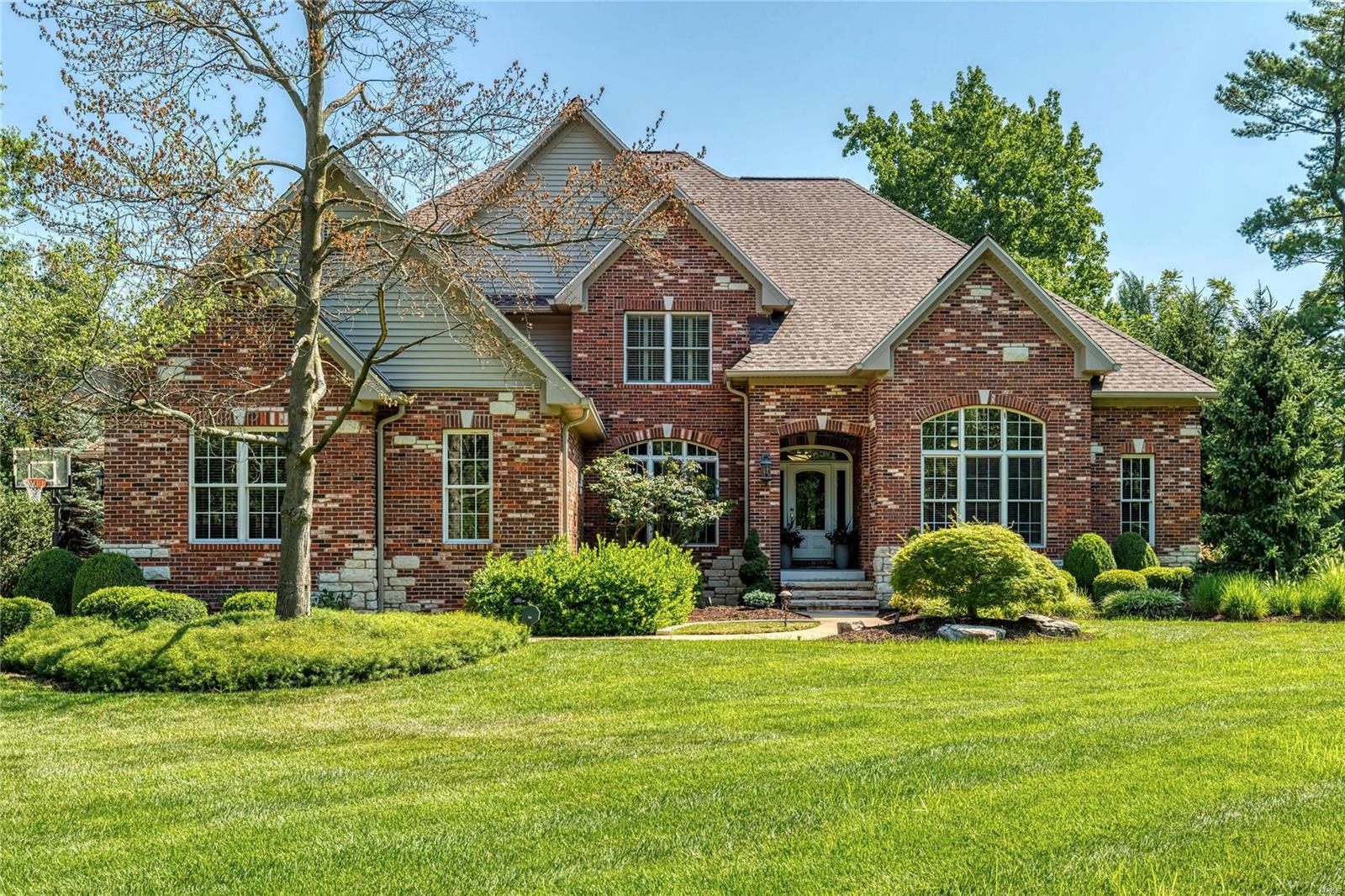 This spectacular brick & stone 1.5 Sty features sophisticated interior detailing & appointments throughout including soaring ceilings, arched entryways, plantation shutters & wide plank oak flooring.  Impressive entry foyer leads to private study, elegant dining room & stunning great room with stone fireplace flanked by 2-sty windows. Designer kitchen with glazed cabinetry, quartz countertops & Thermador appliances adjoins light-filled breakfast room with sliding glass door to sunroom & hearth room highlighted by floor-to-ceiling fireplace. Coffered master bedroom suite with marble bath with jetted tub offers a relaxing retreat. The 2nd floor extends the living quarters with 3 additional bedrooms, 1 with ensuite bath & 2 with Jack n’ Jill bath. Lower Level includes recreation room, game room, gathering bar, workout room, wine cellar & 1 ½ baths. Atrium door opens to outdoor living room with wet bar & full-height fireplace plus resort style pool & spa surrounded by landscaped gardens. Additional Rooms: Sun Room, Wine Cellar