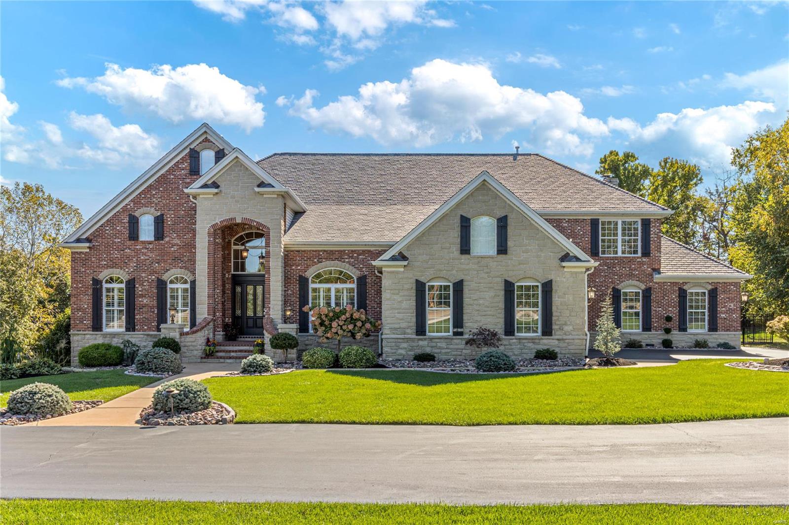 Beautifully designed 8000 sf brick & stone 1.5 Sty. Expansive foyer highlighted by dramatic curved staircase leads to well-appointed study, formal dining room framed by arched entryways & spectacular great room with cast stone fireplace, built-in bookcase & soaring windows.  Designer kitchen with 42” white cabinetry, granite countertops, KitchenAid appliances, butler’s pantry & wet bar adjoins breakfast room with wide bay window & hearth room with floor-to-ceiling brick & stone fireplace. Coffered primary bedroom suite radiates warmth with a direct vent fireplace, lavish bath with jetted tub & adjacent sitting room. The 2nd floor extends the living quarters with 3 additional bedrooms, 1 with ensuite bath & 2 with Jack n’ Jill bath, & bonus room. Lower Level includes recreation room, game room, gathering bar, media room & pool bath. French doors open to outdoor kitchen with grilling station, patio with fire pit, pergola & koi pond plus resort style pool surrounded by landscaped gardens.